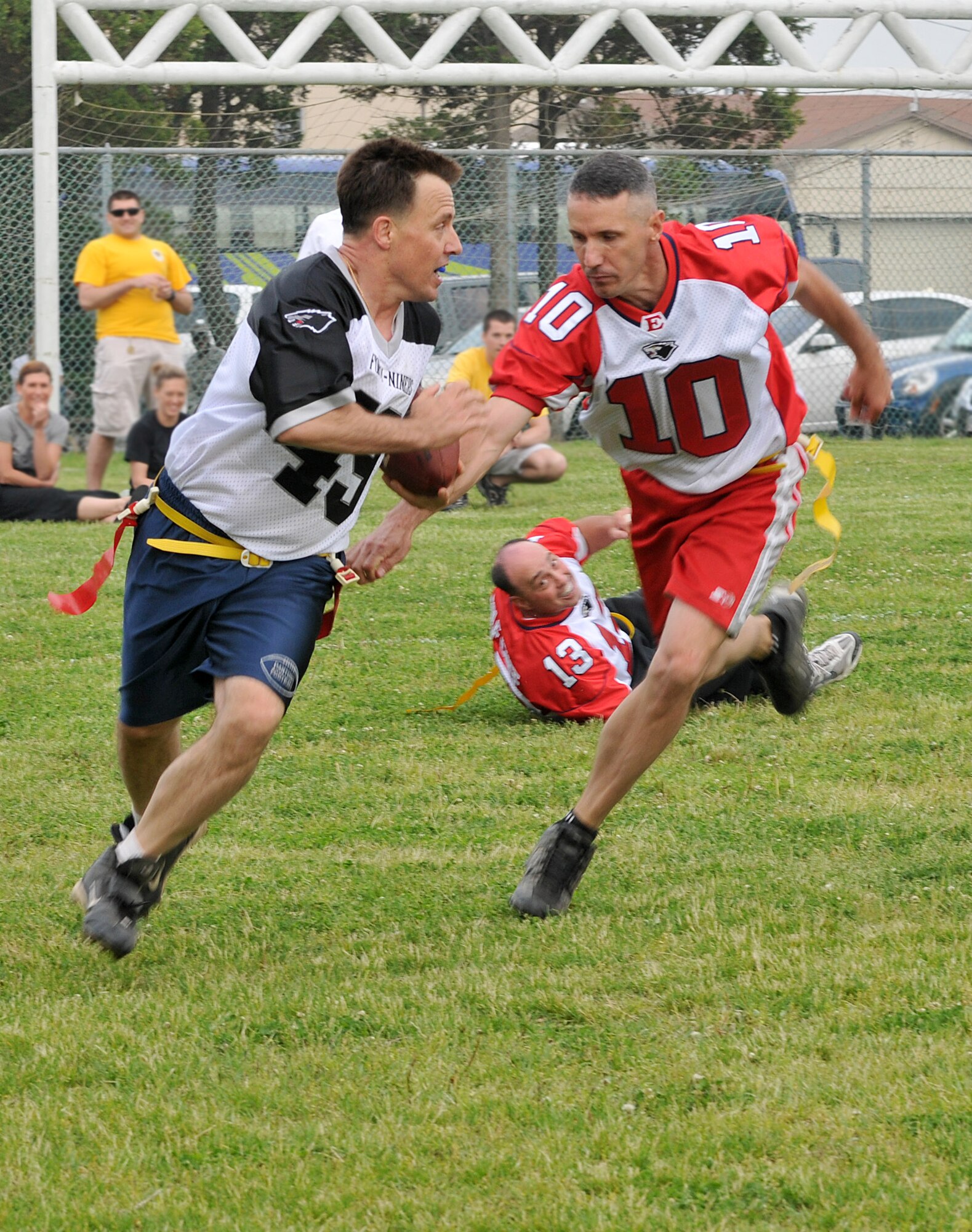KUNSAN AIR BASE, Republic of Korea -- Col. Rob Givens, 8th Fighter Wing commander, snatches an interception and dodges for yards as Chief Master Sgt. James Pruit, 8th Maintenance Group, grabs for the flag during the Chiefs vs. Eagles game May 21 at Kunsan Air Base, Republic of Korea. The Chiefs and Eagles game was a culmination of events that took place throughtout the Junior Enlisted Appreciation Day. The JEAD was hosted by members of the Kunsan Top III Association and supported by wing leadership.