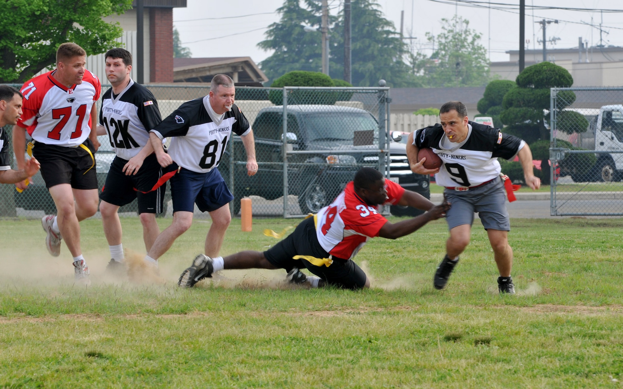 KUNSAN AIR BASE, Republic of Korea -- Maj. Peter Gryzen, 8th Maintenance Operations Squadron commander and Eagles quarterback, runs in a play as Master Sgt. Rafeal Vance, 8th Aircraft Maintenance Squadron, goes for the flag during the Chiefs vs. Eagles game May 21 at Kunsan Air Base, Republic of Korea. The Chiefs and Eagles game was a culmination of events that took place throughtout the Junior Enlisted Appreciation Day. The JEAD was hosted by members of the Kunsan Top III Association and supported by wing leadership.