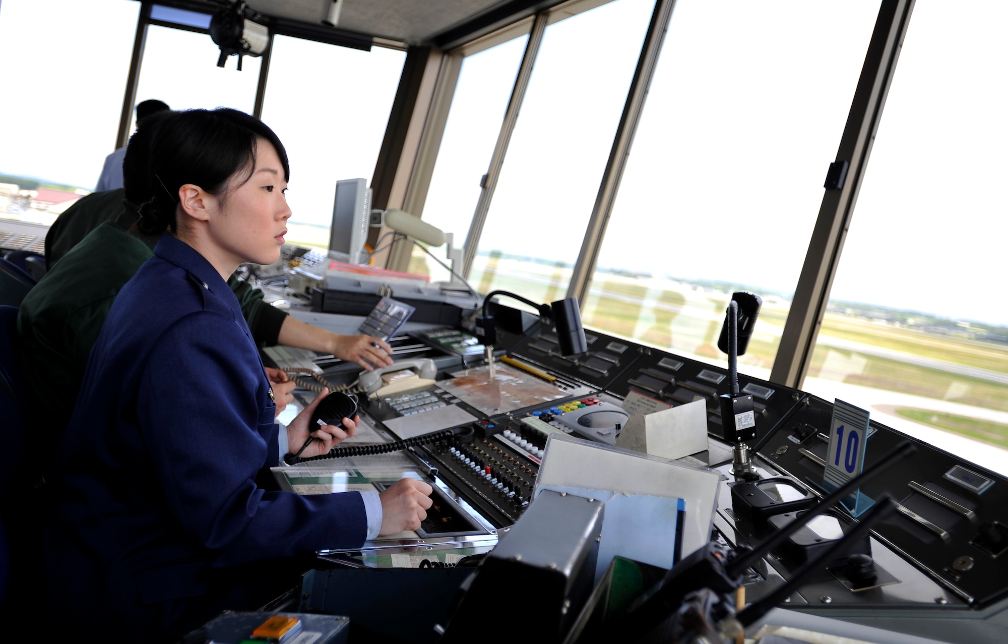 MISAWA AIR BASE, Japan -- Japan Air Self-Defense Force Senior Airman Hitomi Yoneya, air traffic controller, communicates with ground vehicles on the taxiway from the control tower June 3. Here at Misawa, JASDF air traffic controllers communicate with all aircraft and vehicles within Misawa Air Base airspace including JASDF, U.S. Air Force and civilian airlines. (U.S. Air Force photo/Staff Sgt. Chad C. Strohmeyer)