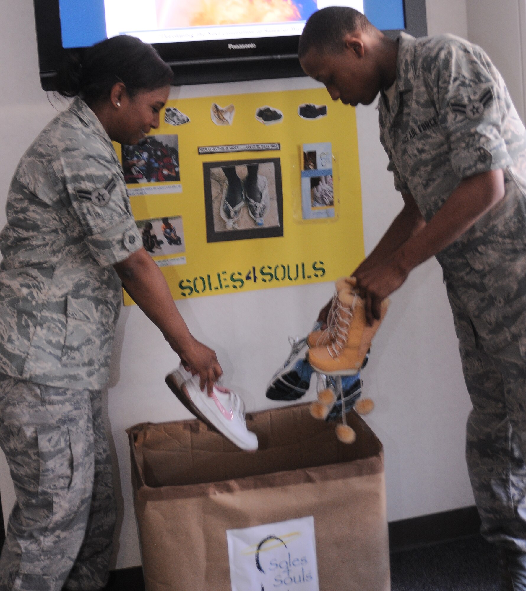 YOKOTA AIR BASE, Japan -- Airman 1st Class Vanessa Villar, 374th Operations Group intelligence analyst and Airman 1st Class Larry Morris, 374th Operations Group intelligence analyst donate gently worn shoes at a Soles4Souls drop-off point in Building 703, June 3. Soles4Souls was started after Hurricane Katrina by Wayne Elsey when he saw the devastation that it caused and the needs of those affected. The organization travels around the world distributing shoes to people in places struck by natural disaster or tremendous poverty.(U.S. Air Force photo/Airman 1st Class Lynsie Lorenz)