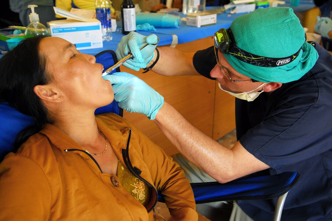 U.S. Navy Cmdr. (Dr.) Ray Dailey administers a shot of numbing medication prior to a tooth extraction to a local Vietnamese patient during a dental civic action program, Quy Nhon, Vietnam, June 2, 2010.