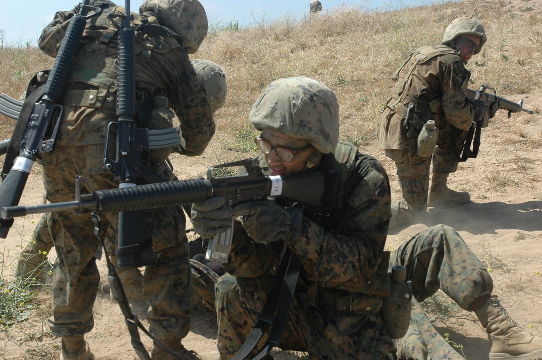 Pfc. Patrick Collman provides covering fire while his fellow new Marines help another simulated wounded Marine during the Crucible at Camp Pendleton, Calif.,  June 3.