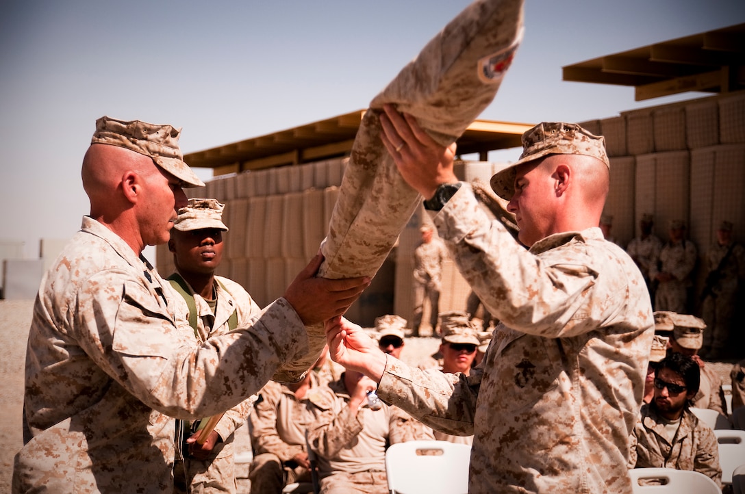 Lt. Col. Jeffrey C. Holt and Sgt. Maj. Andrew T. Cece, commanding officer and sergeant major, 3rd Battalion, 3rd Marine Regiment, unfurl the battalion colors during a transfer of authority ceremony at Forward Operating Base Geronimo where 3/3 took over 1st Battalion, 3rd Marine Regiment’s are of operations, June 6.