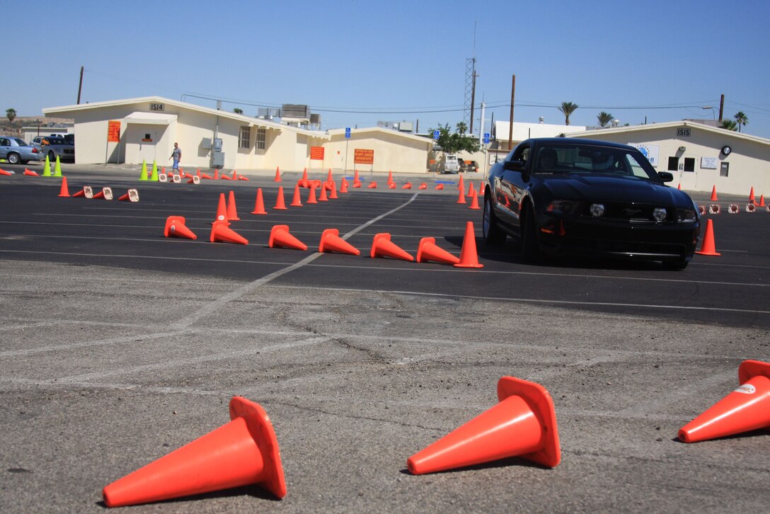 A Combat Center Marine takes a Ford Mustang for a high-speed spin on the makeshift precision driving course across the street from the Main Exchange during the Ford: Operation Drive One event June 4. With professional drivers in the passenger seats of the vehicles, the course allowed service members and their families a chance to try out driving techniques not legal on normal roads.
