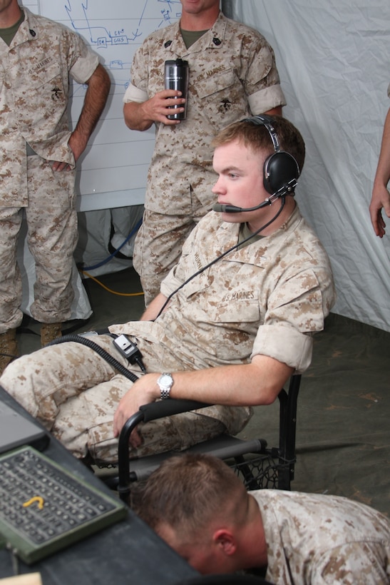 First Lt. Austin Murnane, 3rd Light Armored Reconnaissance Battalion’s assistant operations officer, listens to radio traffic while observing simulated troop movements during Command Post Exercise Menacing Name, a combat operations center training exercise, at the battalion’s light armored vehicle ramp June 4. Murnane served as the watch commander for the exercise, which is designed to help familiarize Marines with COC systems and operations.
