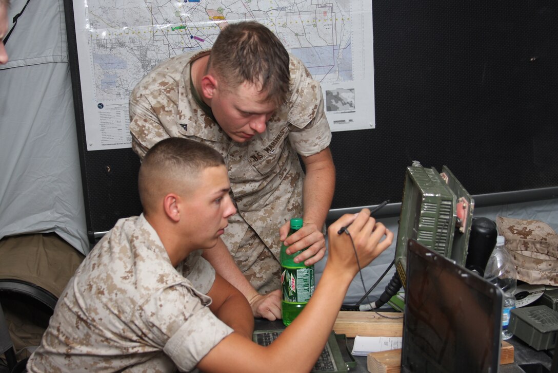 Lance Cpl. Randall Harness, a communications repairman with 3rd Light Armored Reconnaissance Battalion, helps Lance Cpl. Adam Smith, a blue force tracker in 3rd LAR’s combat operations center, troubleshoot BFT equipment during Command Post Exercise Menacing Name, a COC training exercise, at the battalion’s light armored vehicle ramp June 4. Maintaining equipment is essential for COC personnel to gather and store intelligence reports and other useful information about their area of operations.