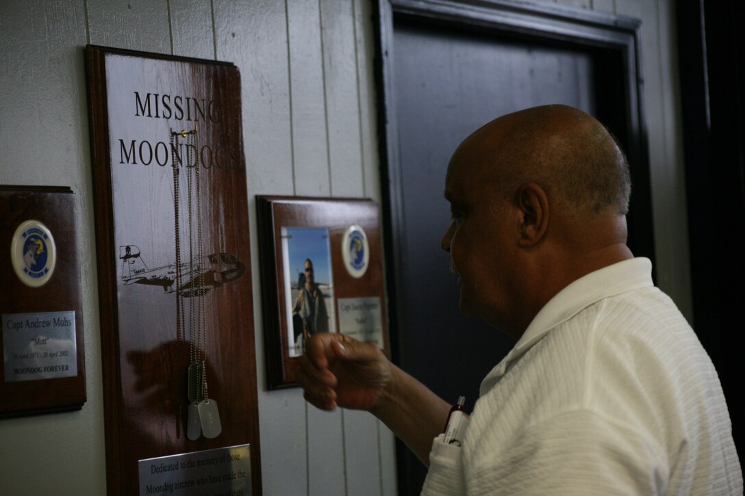 Burton S. Paynter hangs the dog tags of his late son, Capt. Jason J. Paynter, on a plaque in the ready room of Marine Tactical Electronic Warfare Squadron 3 during a ceremony, June 4. VMAQ-3 dedicated its ready room to Paynter and Capt. Andrew Muhs, fallen pilots who once served in the squadron.