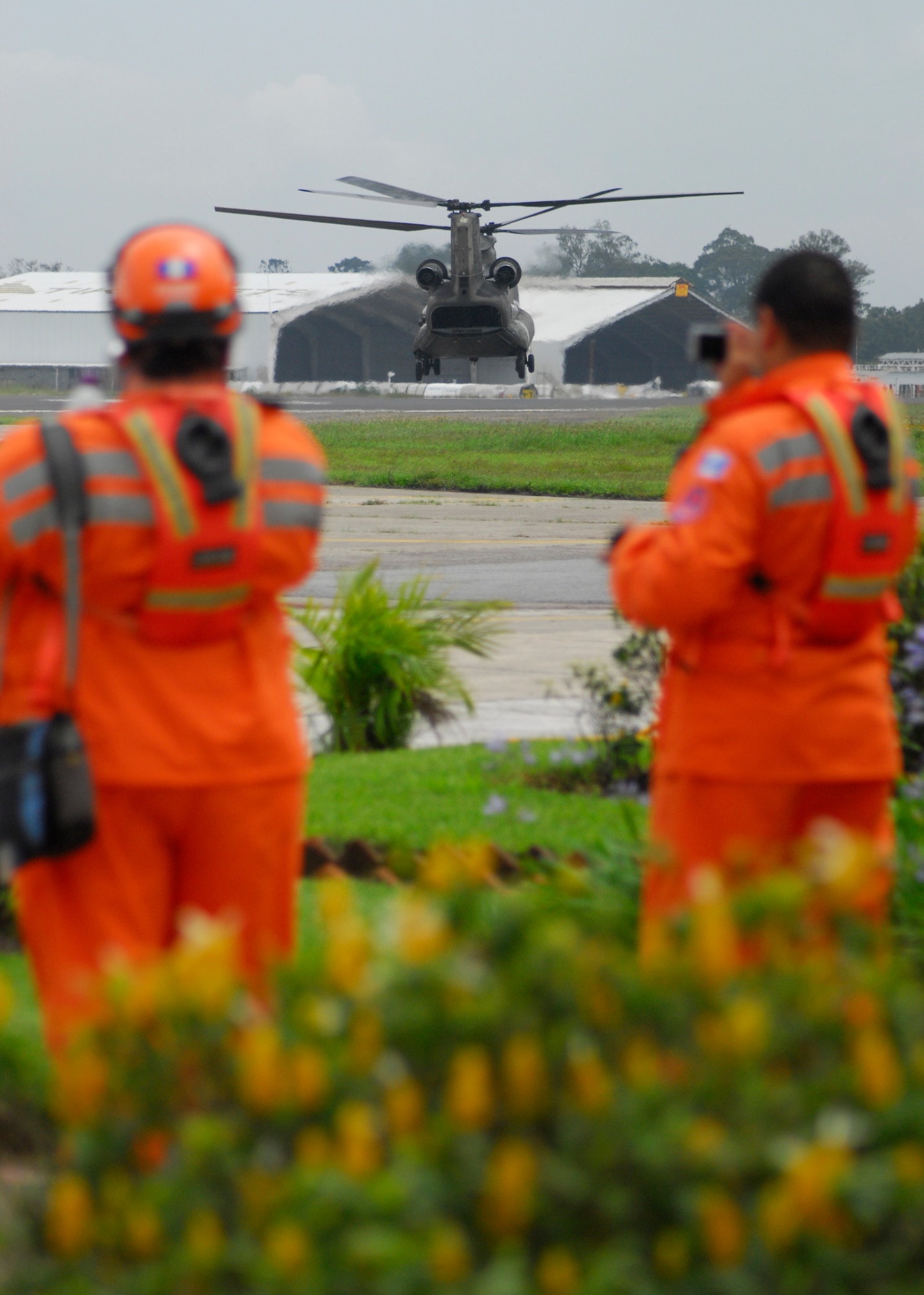 Members from Coordinadora Nacional para la Reduccion de Desastres (CONRED) watch a Joint Task Force-Bravo CH-47 Chinook take off from the Guatemala City Airport June 4 to deliver food and water to communities affected by Tropical Storm Agatha and the Pacaya Volcano. Joint Task Force-Bravo’s helicopters and personnel transported nearly 53,000 pounds of relief supplies June 3-4 to Guatemalan communities in need. (U.S. Air Force photo by Staff Sgt. Bryan Franks)