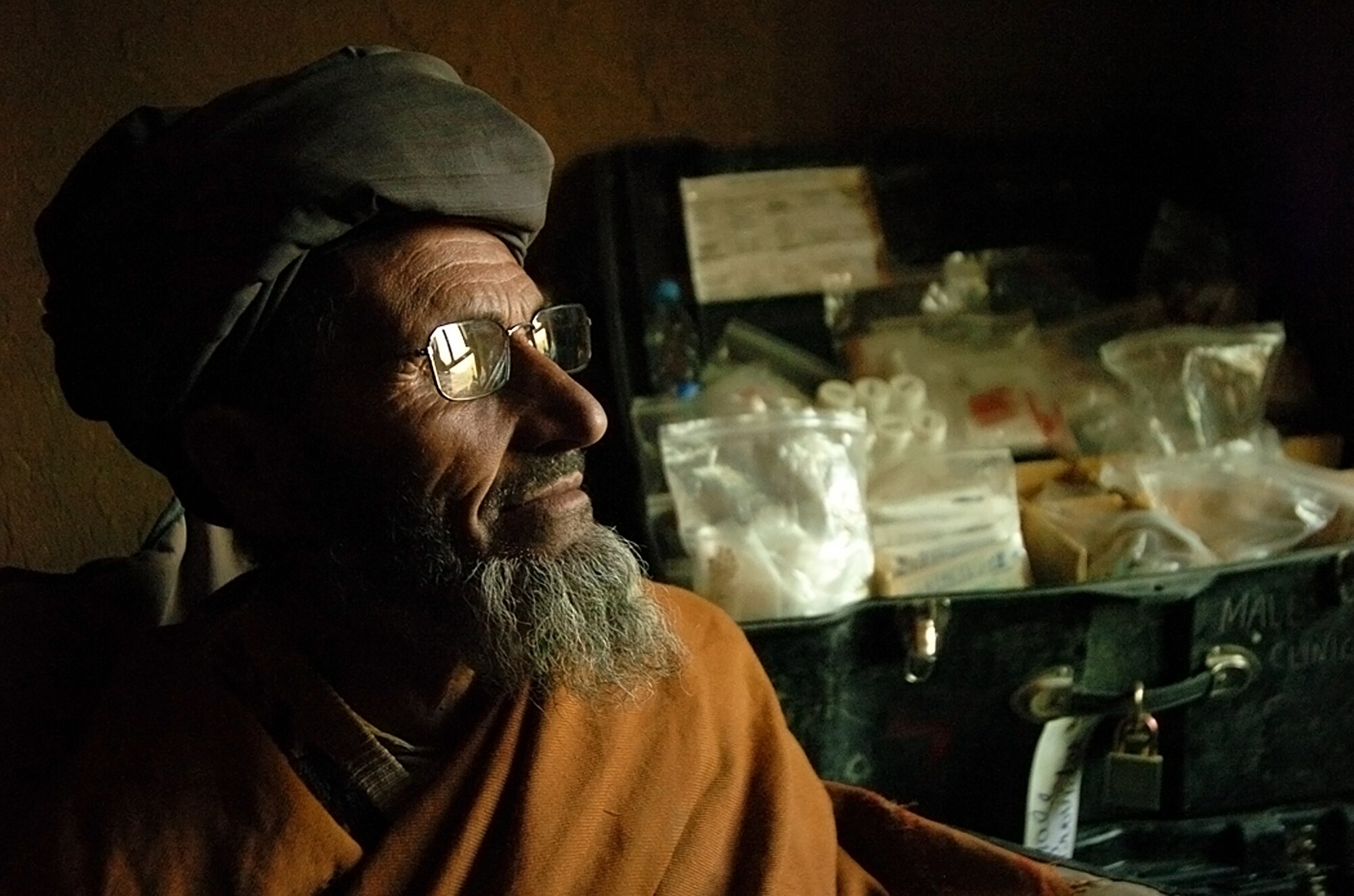 An Afghan man tries on a pair of glasses and observes the area around him, for the first time in many years, during a medical outreach program May 15, 2010. (U.S. Air Force photo/Senior Airman James Bolinger)