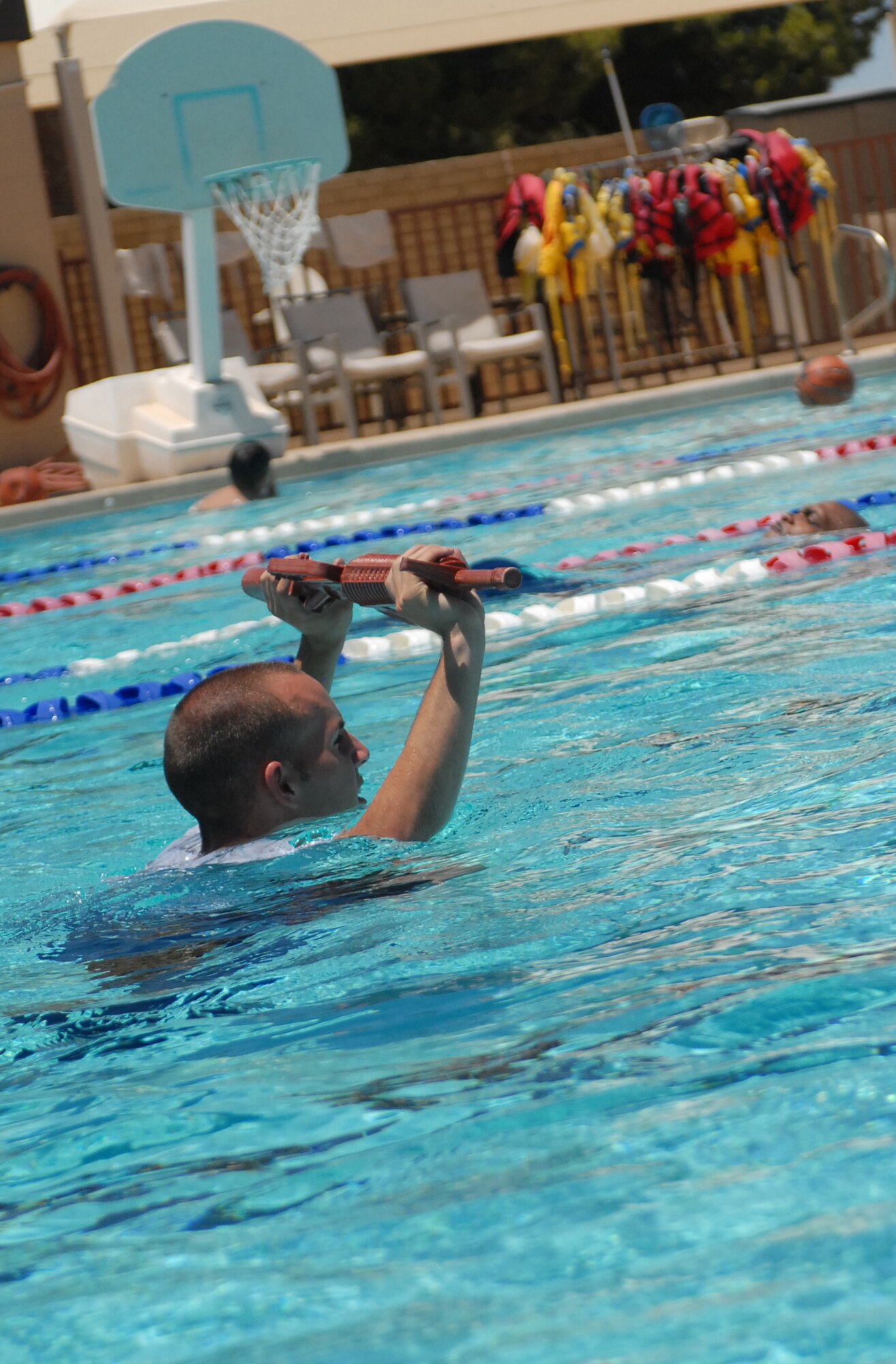 Airman 1st Class Christopher Copeland, 56th Security Forces Squadron, performs a red man rifle carry in the Silver Wings Pool during a Cross fit H2O workout, May 27.  (U.S. Air Force photo by Airman 1st Class Sandra Welch)   