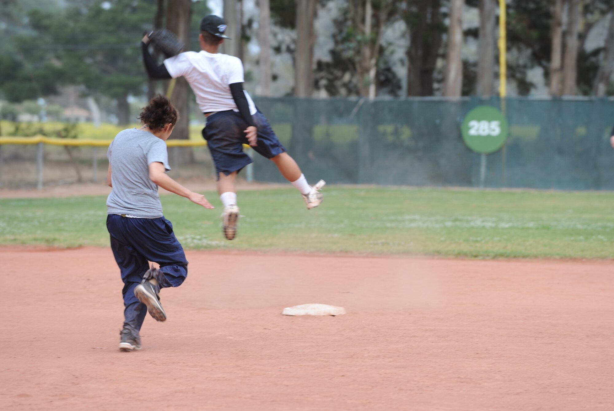 VANDENBERG AIR FORCE BASE, Calif. -- Amanda Trei, a 30th Force Support Squadron softball team member, rushes for second base as Joel Rivera, coach for the 381st Training Squadron softball team, leaps for the ball during an intramural softball game here behind the old gym Thursday, June 3, 2010. Fourteen teams are signed up to play in the intramural softball tournament, which will last for approximately two months. (U.S. Air Force photo/Senior Airman Ashley Reed)