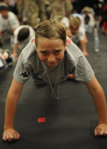 DYESS AIR FORCE BASE, Texas-- Devon Grenfell, 11 years old, does push-ups during physical training at Operation Dyess Kids June 4 here. Devon is the son of Jeff Grenfell, 7th Equipment Maintenance Squadron. The purpose of Operation Dyess Kids was to help the children understand why parents deploy and what they go through during a deployment, as well as to encourage parent-child communication. The program aimed to ease some of the tension children have about their parents' deployments, which allows the deployers to focus on the mission.(U.S Air Force photo/ Airman 1st Class Shannon Hall)