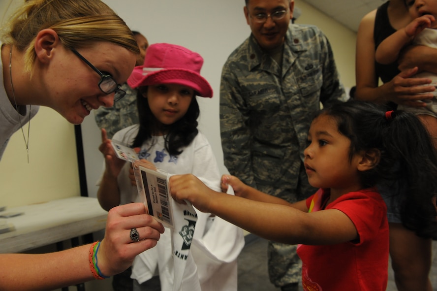 DYESS AIR FORCE BASE, Texas-- (from left to right) Ariela Sarabia,6, and younger sister Olivia, 3, receive their military identification cards during Operation Dyess Kids June 4 here. Ariela and Olivia are the daughters of David Sarabia, 317th Airlift Group. The purpose of Operation Dyess Kids was to help the children understand why parents deploy and what they go through during a deployment, as well as to encourage parent-child communication. The program aimed to ease some of the tension children have about their parents' deployments, which allows the deployers to focus on the mission.(U.S Air Force photo/ Airman 1st Class Shannon Hall)