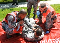 During an emergency response exercise at Travis Air Force Base, California on 12 May 2010 Travis medical personal, left, Staff Sergeant Bernard Bueno and Airman First Class Chris Dixon members of the Medical Operations Squadron provide care to a simulated victim. (U.S. Air Force photo by Civ/Jay Trottier)