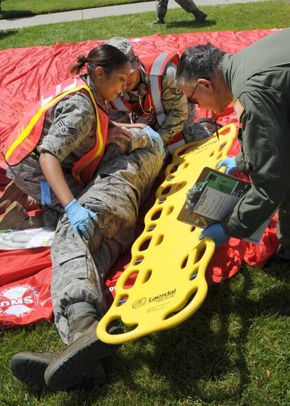 During an emergency response exercise at Travis Air Force Base, California medical personal, left to right, Senior Airman Dalkas Hicks, Staff Sergeant Bernard Bueno, both members of the Medical Operations Squadron and Lieutenant Colonel George Estes, member of the Aerospace Medicine Squadron work together to transport a simulated victim to a waiting ambulance. (U.S. Air Force photo by Civ/Jay Trottier) 