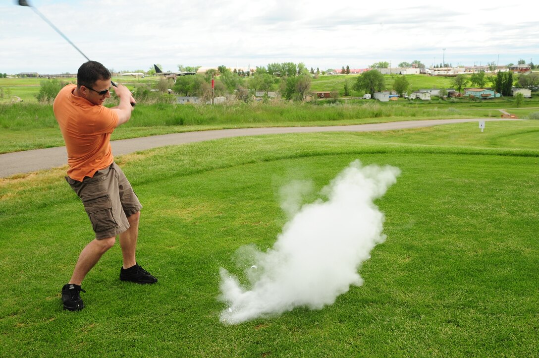 ELLSWORTH AIR FORCE BASE, S.D. -- Senior Airman Kurt Meliet, Air Force Financial Services Center Air Mobility Command relocation technician, strikes a fake golf ball as a team prank during a golf tournament, June 4.  The Diamond in the Rough golf tournament was sponsored by the First Sergeant's Association. (U.S. Air Force photo/Airman 1st Class Anthony Sanchelli)