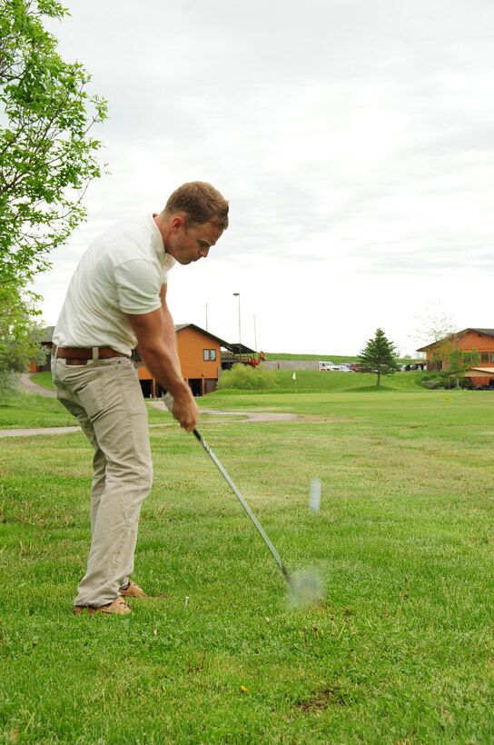 ELLSWORTH AIR FORCE BASE, S.D. -- Airman 1st Class Evan McPhail, 28th Maintenance Squadron avionics technician, strikes the ball during the Diamond in the Rough golf tournament, June 4.  The tournament was sponsored by the First Sergeant's Association as a morale booster. (U.S. Air Force photo/Airman 1st Class Anthony Sanchelli)