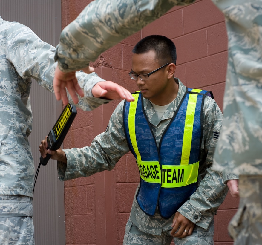 LANGLEY AIR FORCE BASE, Va. – Senior Airman Wilbur Raguini, 633d Civil Engineer Squadron baggage team member, searches Langley Airmen for prohibited items prior to their deployment to Andersen Air Force Base, Guam, June 2. The deployment, which will last approximately four months, is a prudent measure to maintain a credible deterrent posture and presence for the region and demonstrate a continued U.S. commitment to fulfilling security responsibilities throughout the Western Pacific. (U.S. Air Force photo/Staff Sgt. Barry Loo)