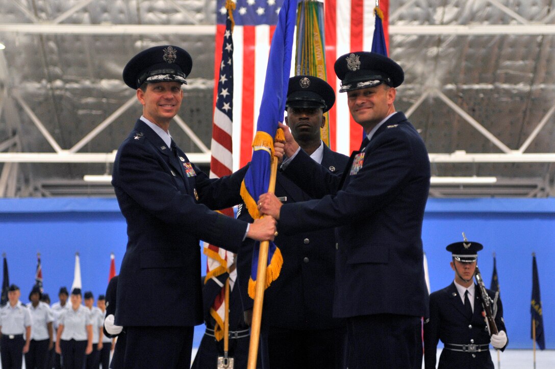 JOINT BASE ANDREWS, Md. -- Maj. Gen. Darrell D. Jones, Air Force District of Washington commander, passes the guidon to Col. Kenneth R. Rizer, as he assumes command of the 316th Wing June 4, 2010. Col. Rizer assumed command from Col. Steven Shepro and hails from Camp Smith, Hawaii. (U.S. Air Force photo by Staff Sgt. Renae Saylock)