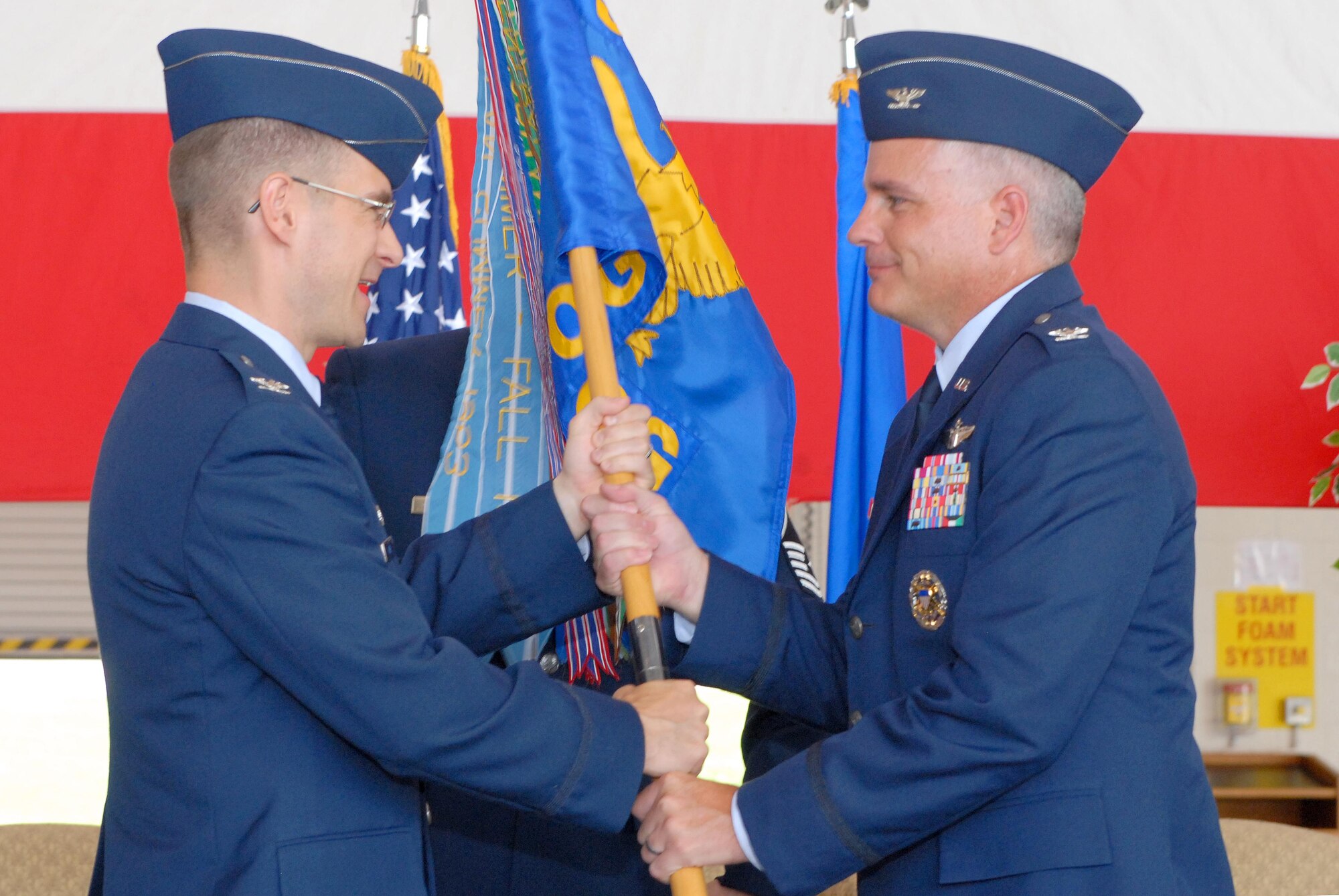 Col. C.K. Hyde, 314th Airlift Wing commander, passes the 314th Operations Group guidon to Col. Michael Bauer upon assuming command of the group, June 4, on base. Col. Bauer is returning to Little Rock AFB for his third time after previously commanding the 61st Airlift Squadron several years ago. (U.S. Air Force photo by Senior Airman Steele C. G. Britton)
