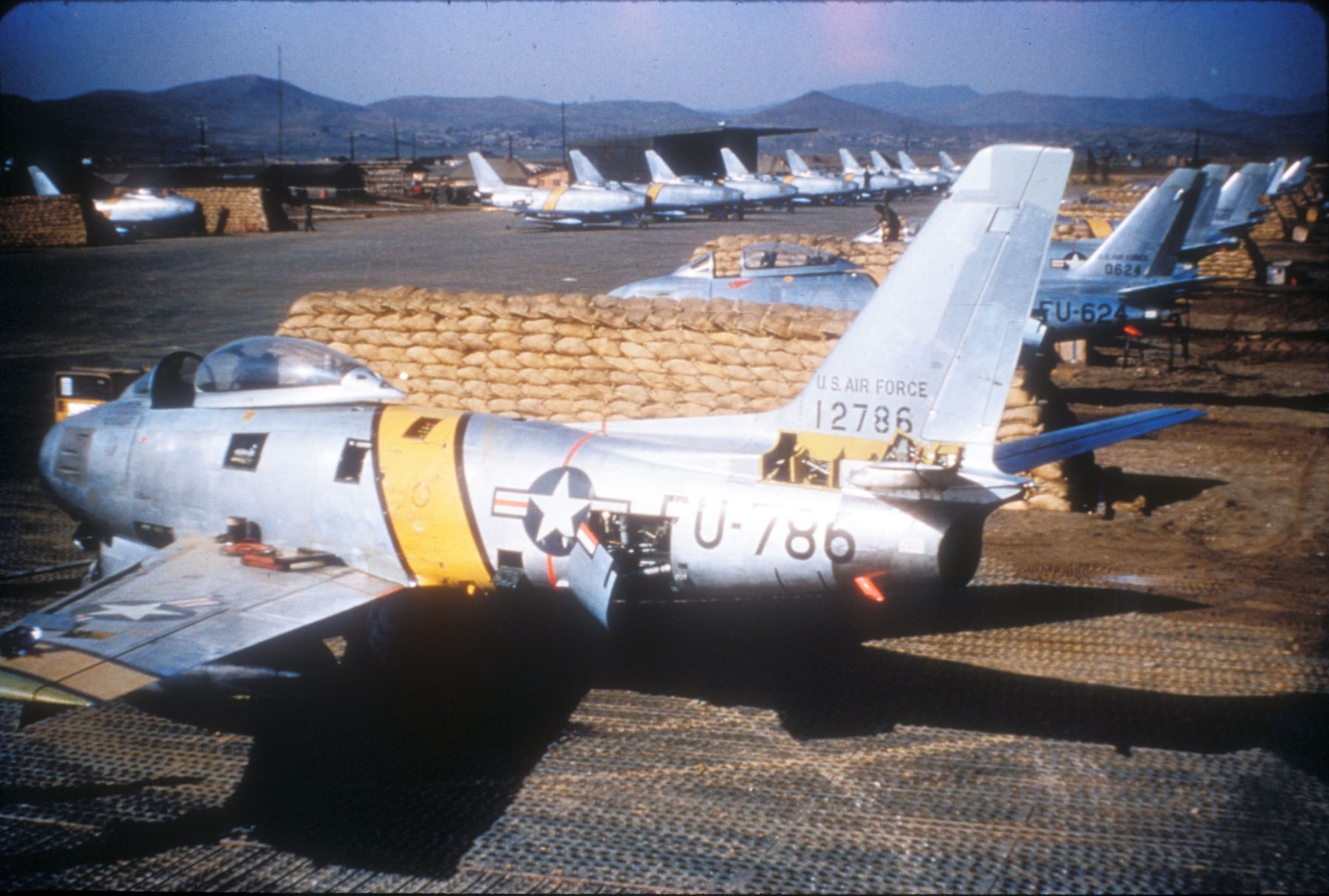 F-86s parked in sandbag revetments on an air base in Korea. The sandbags protected aircraft from bomb fragments. (U.S. Air Force photo)