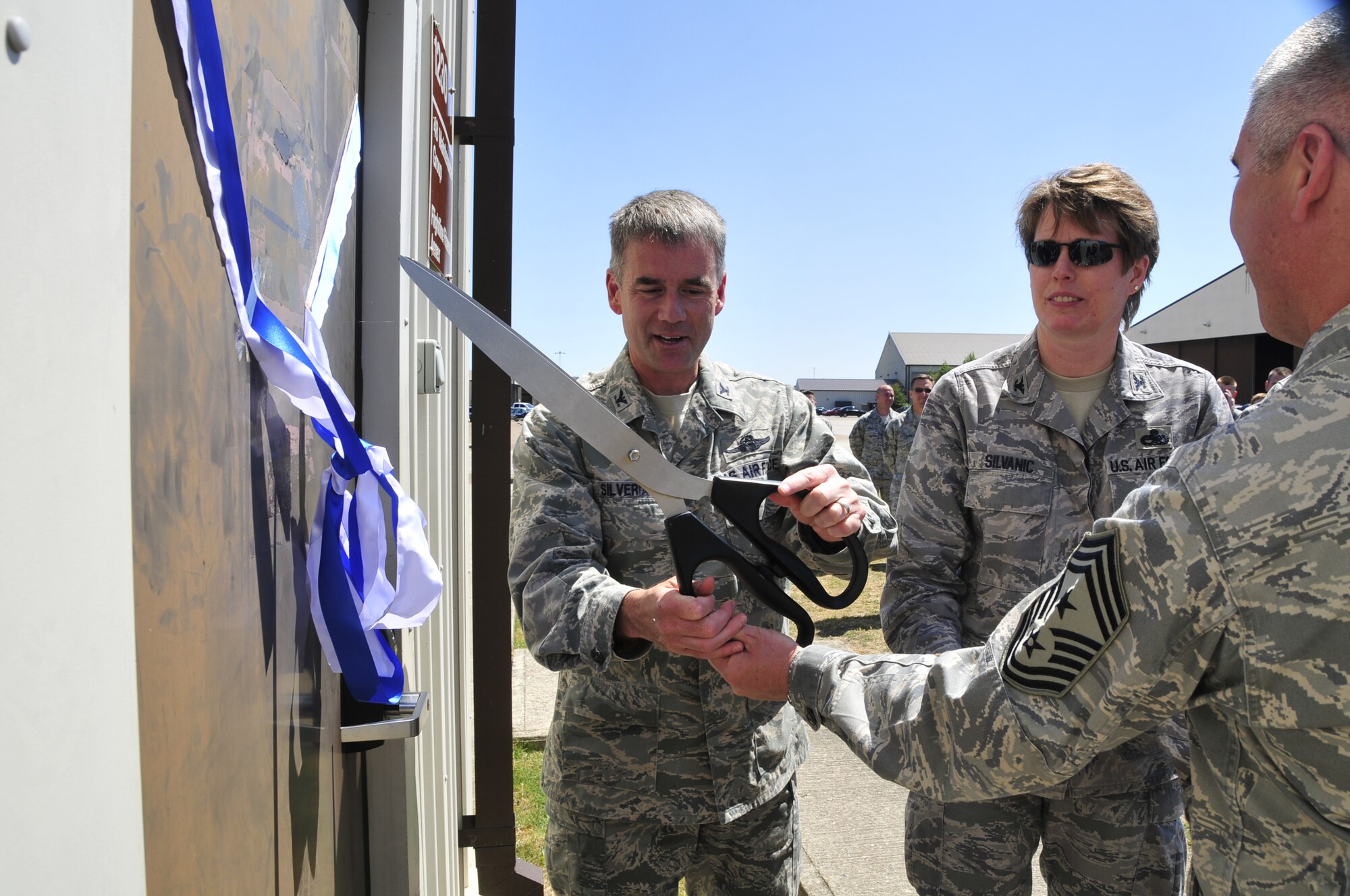 Col. Jay Silveria, 48th Fighter Wing commander, cuts the ribbon at the flightline fitness annex grand opening while Chief Master Sgt. James Lucas, 48th Fighter Wing command chief, and Col. Dorothy Silvanic, 48th Maintenance Group commander, assist June 3. The new flightline gym, located near Hangar 7, is open 24 hours a day to match the on-going mission of the flightline. (U.S. Air Force photo/Airman 1st Class Eboni Knox)