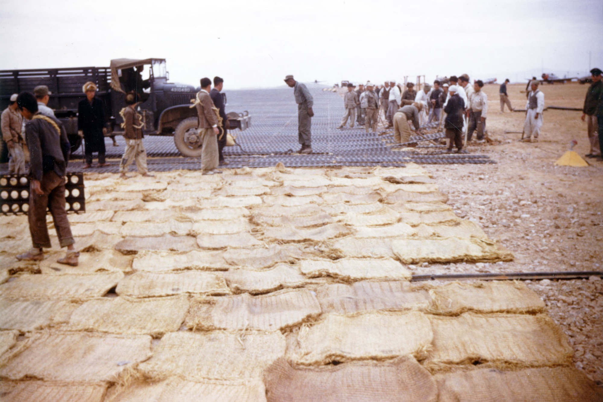 Most runways at Korean bases were made of “temporary” PSP (Pierced Steel Planking) that required constant maintenance. Here, the runway at K-6 (Pyongtaek) is being lengthened with PSP laid on top of rice bags. (U.S. Air Force photo)