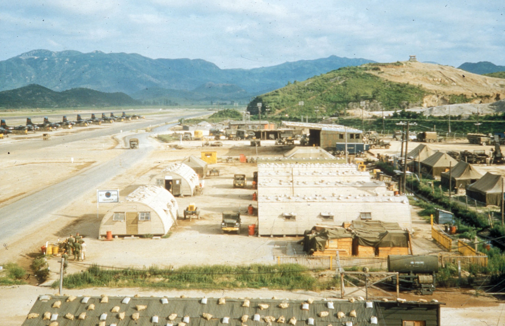 This photo of K-9 (Pusan East) in June 1953 shows a typical Korean air base at the end of the war. There are temporary corrugated metal buildings in the middle, while on the right are tent barracks. The B-26 aircraft on the left are parked in the open, exposed to the elements. (U.S. Air Force photo)