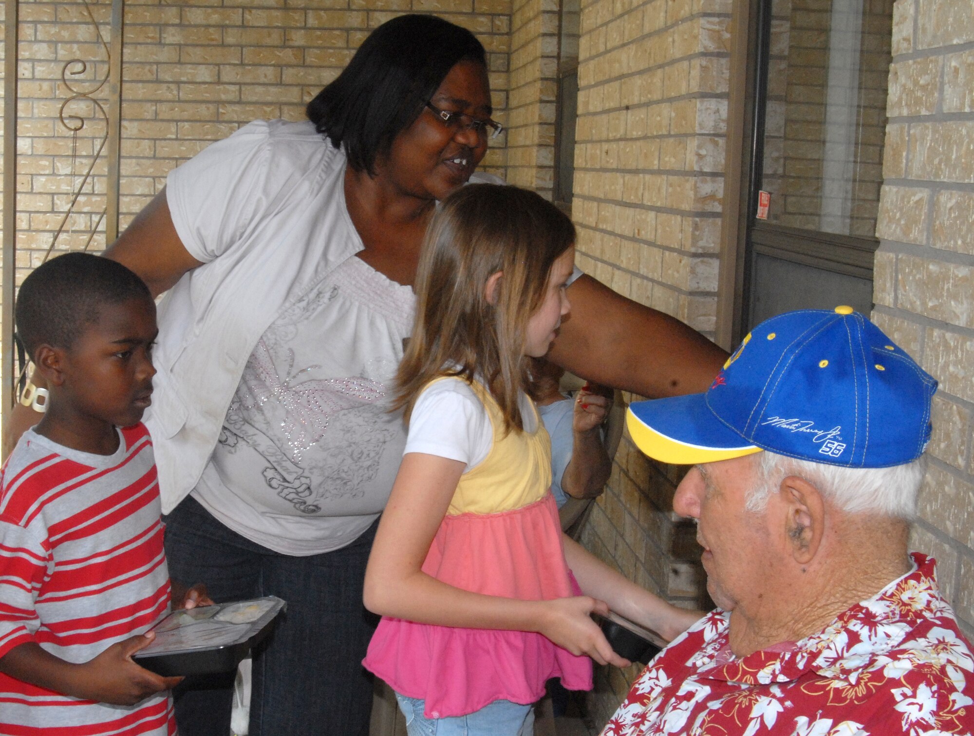 Goodfellow Summer Camp members, Marquis Cole, 9, and Olivia Mosher, 10, deliver meals to the elderly around the city June 3 with the help of Stacie Miles, summer camp staff, as part of the San Angelo Meals for the Elderly program. Summer Camp participants are able to volunteer to deliver meals once a month during the summer. (U.S. Air Force photo/Connie Hempel)