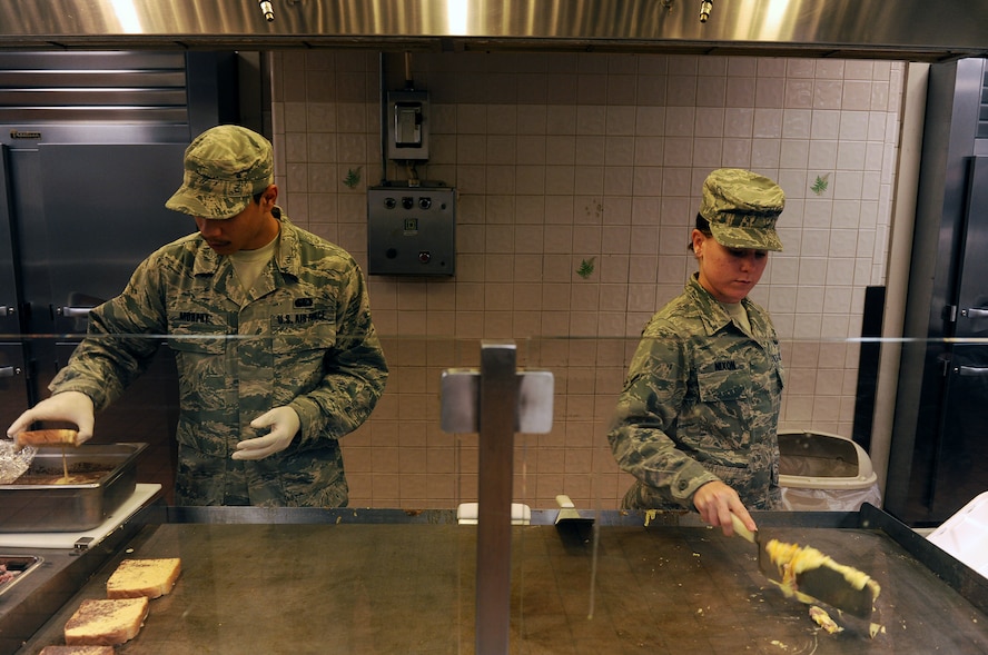 MOODY AIR FORCE BASE, Ga. -- Airman 1st Class Rondel Murphy, 23rd Force Support Squadron food services journeyman and Airman Ashton Nixon, 23rd Force Support Squadron food services apprentice prepares French toast and scrambled eggs for Airmen coming in for breakfast at the dining facility here May 25. (U.S. Air Force photo by Airman 1st Class Joshua Green/RELEASED)