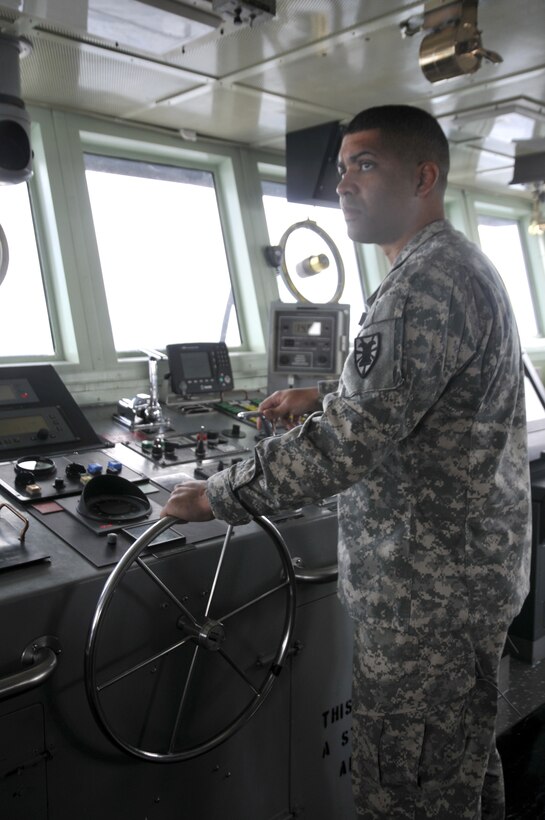 Chief Warrant Officer Johnett Razon navigates the LCU-2005 Brandy Station, which carried a 20-foot radar used to track the launch of the Atlantis Space Shuttle.
