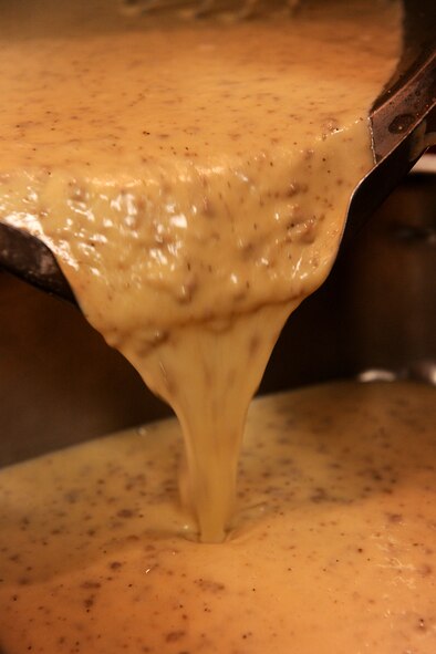 MOODY AIR FORCE BASE, Ga. -- Creamed beef is poured from a pot to a pan to be placed on the food line for breakfast here May 25. All the cooks contracted or Airmen show up for work around 4 AM and work through the lunch rush. (U.S. Air Force photo by Airman 1st Class Joshua Green/RELEASED)