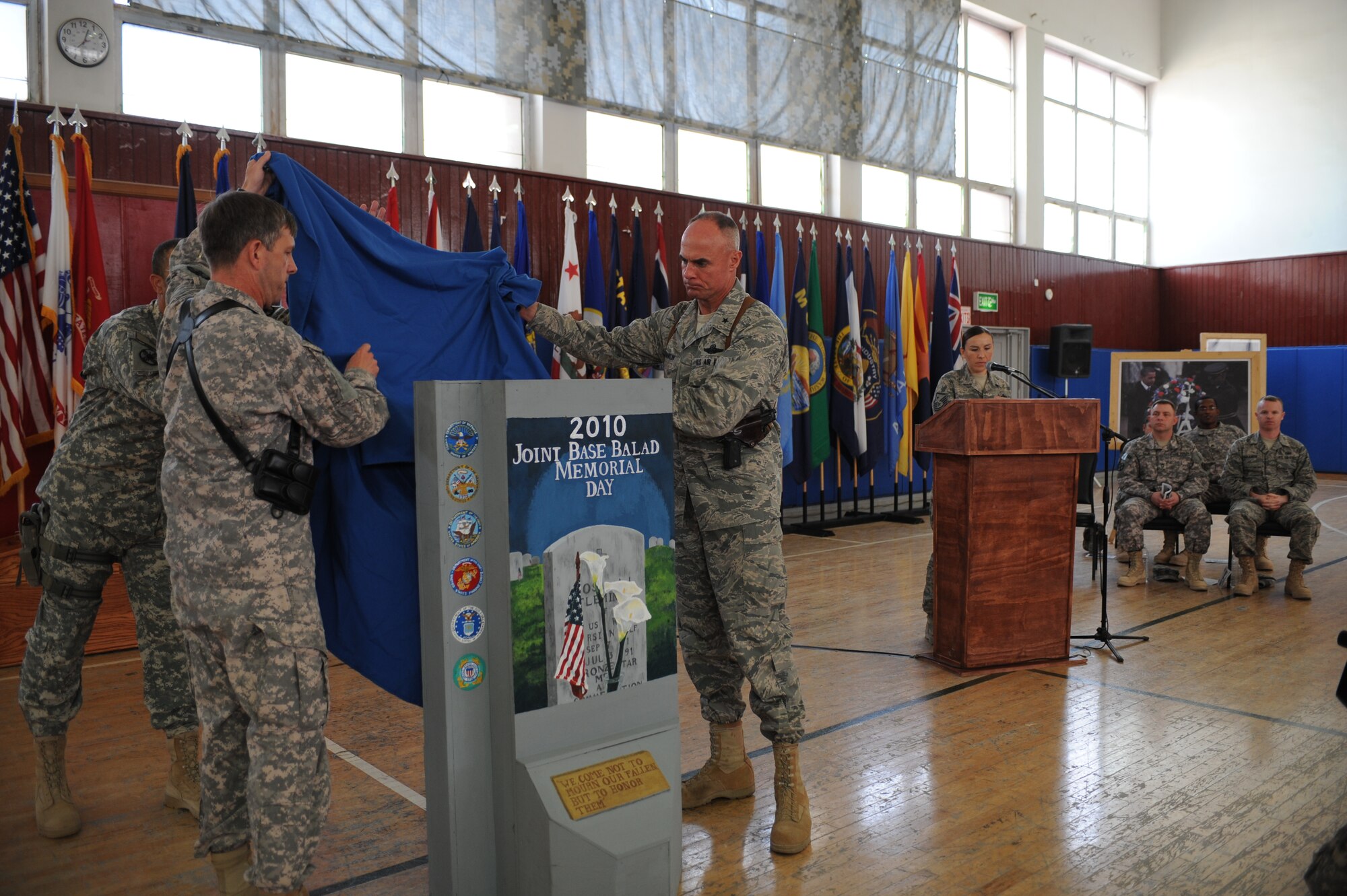 Army Brig. Gen. Paul L. Wentz, 13th Expeditionary Sustainment Command Commander and Air Force Brig. Gen. Craig A. Franklin, 332nd Air Expeditionary Wing Commander, unveil a mini T-wall memorial during the Memorial Day ceremony at Joint Base Balad, Iraq, May 31, 2010. The ceremony consisted of the memorial unveiling, musical performances, reading of the proclamation from President Obama, and guest speakers representing the Air Force, Navy, Coast Guard, and Army sharing stories of fellow personnel that made the ultimate sacrifice for their nation.  (U.S. Air Force photo/Master Sgt. Linda C. Miller)