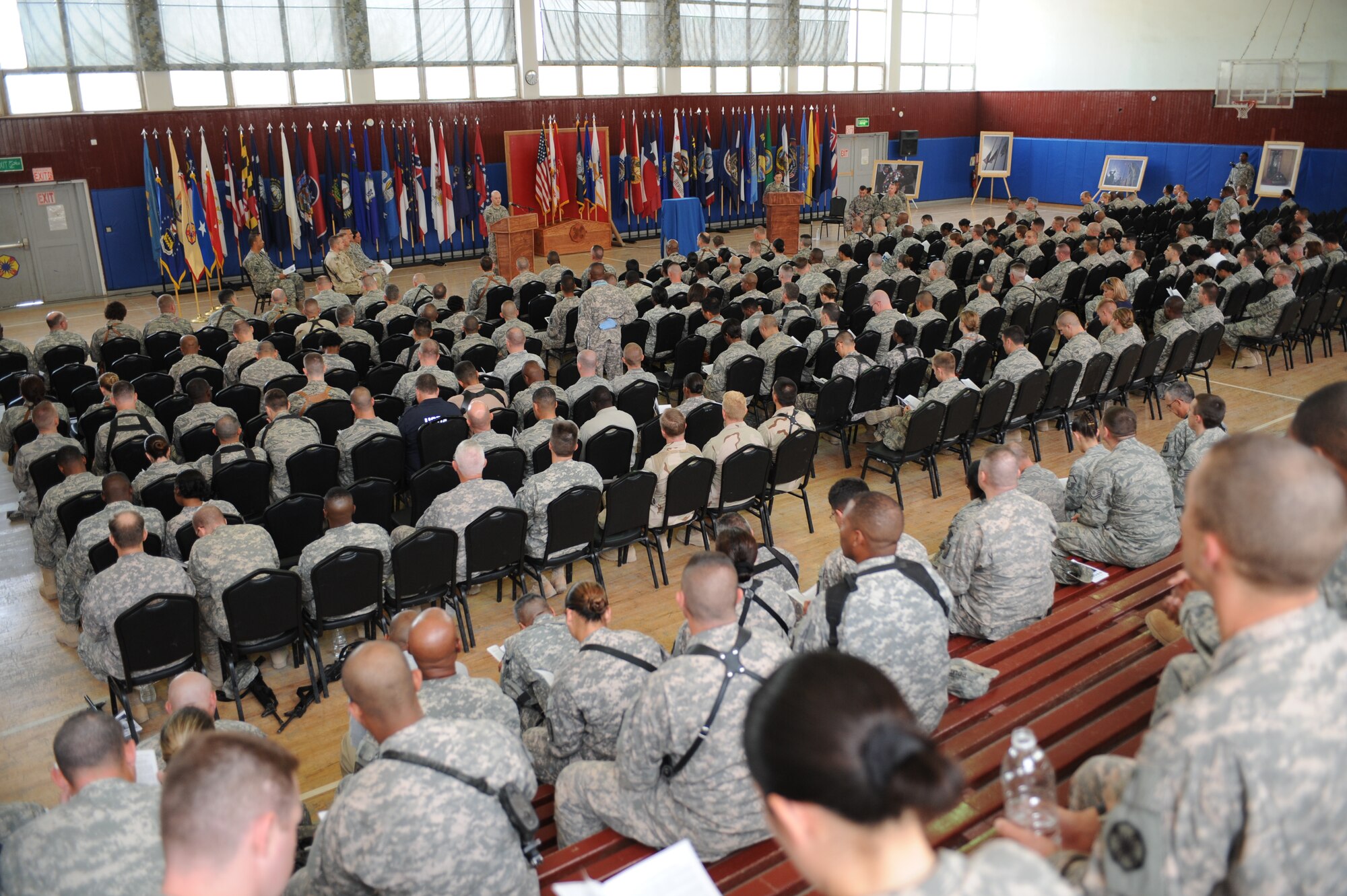 Airmen, Soldiers, Sailors, and civilians, listen to the reading of the proclamation from President Obama during the Memorial Day ceremony at Joint Base Balad, Iraq, May 31, 2010. The ceremony consisted of the unveiling of a mini T-wall memorial, musical performances, reading of the proclamation from President Obama, and guest speakers representing the Air Force, Navy, Coast Guard, and Army sharing stories of fellow personnel that made the ultimate sacrifice for their nation.  (U.S. Air Force photo/Master Sgt. Linda C. Miller)