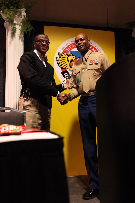 Col. Grover C. Lewis III, Marine Forces Command, assistant chief of staff for the Department of Public Safety, presents the “Excellence in Leadership” award to Sir Edward Toussaint Staten at the Bayou Classic coaches’ luncheon Nov. 26. Grambling State University beat Southern University in the Bayou Classic the next day.
