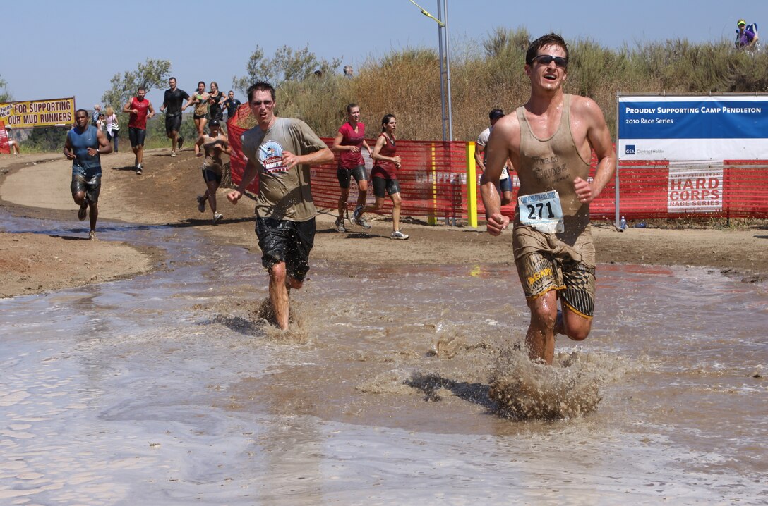 Cris Phelps (right) makes his way to the finish line, coming in at just over one hour during the 2010 Camp Pendleton Mud Run at Lake O'Neil, June 5. During the event, runners must traverse tire obstacles, river crossings, two 5-foot walls surrounded by mud and water, tunnel crawls, slippery hill climbs, and a 30-foot mud pit. The event was hosted by Marine Corps Community Services and is part is part of Marine Special Operations Command’s Hard Corps Race Series.