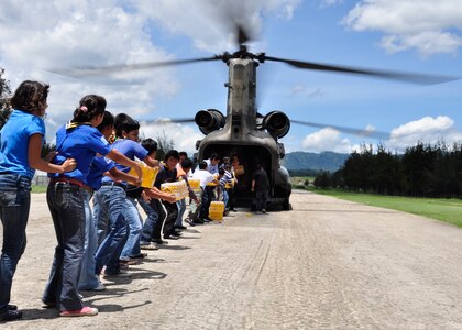 Young and old alike begin offloading food and water from a Joint Task Force-Bravo CH-47 Chinook June 5 in the community of Santa Cruz del Quiche, Guatemala. Joint Task Force-Bravo’s helicopters have transported approximately 94,000 pounds of relief supplies to Guatemalan communities since June 2, in support of the Guatemalan government's disaster relief efforts following the Pacaya Volcano eruption and Tropical Storm Agatha. (U.S. Air Force photo by Staff Sgt. Bryan Franks)

