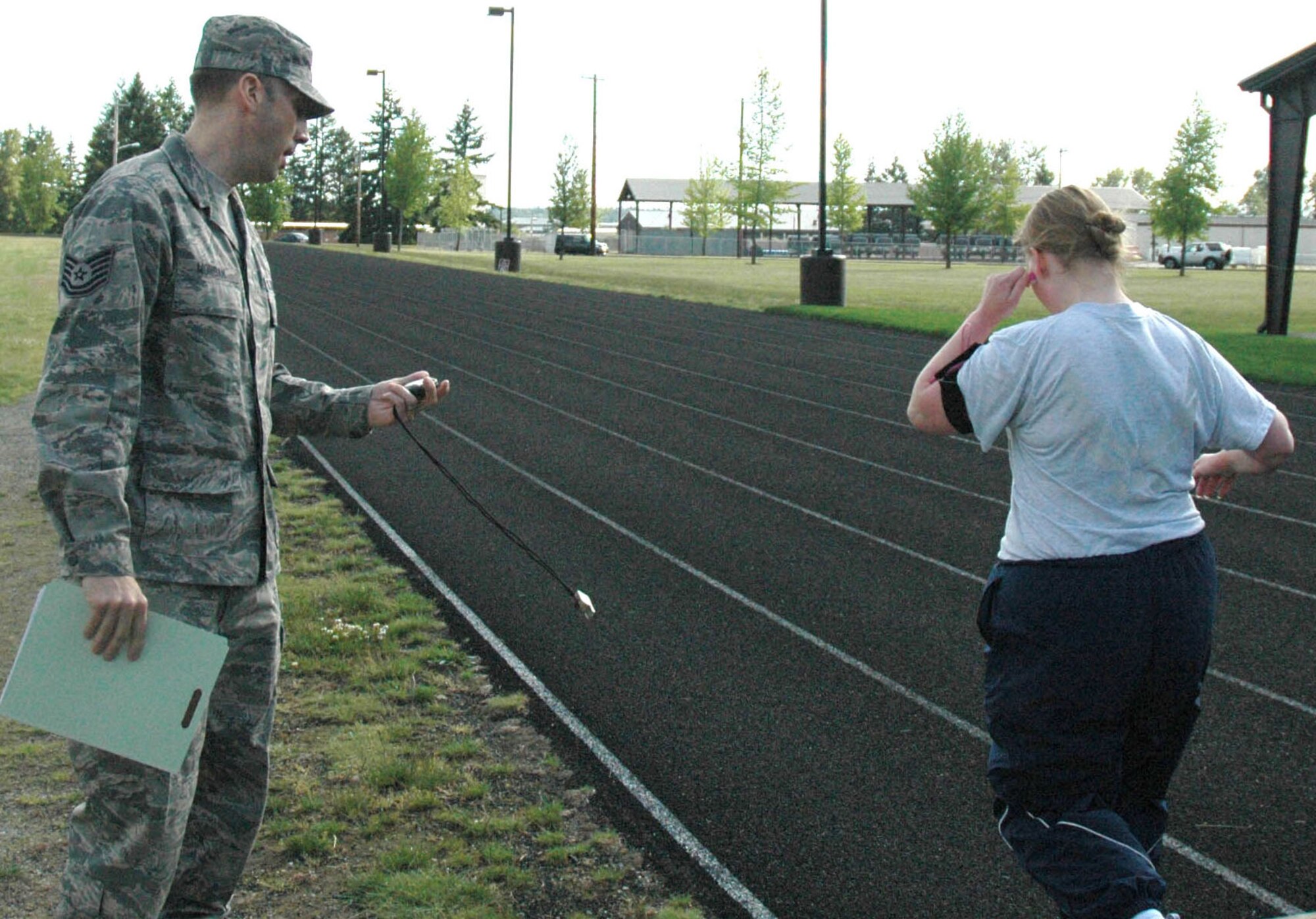 JOINT BASE LEWIS-MCCHORD, Wash. - Tech. Sgt. Shane Morgan, relocations adviser with 446th Mission Support Squadron, updates an Airmen on her speed as he monitors her fitness test. Sergeant Morgan will be one of the Reservist fitness monitors who will augment the Fitness Assessment Cells at McChord Field, here as part of the Air Force new fitness program, which comes into effect July 1. (U.S. Air Force Photo/Staff Sgt. Nicole Celestine)