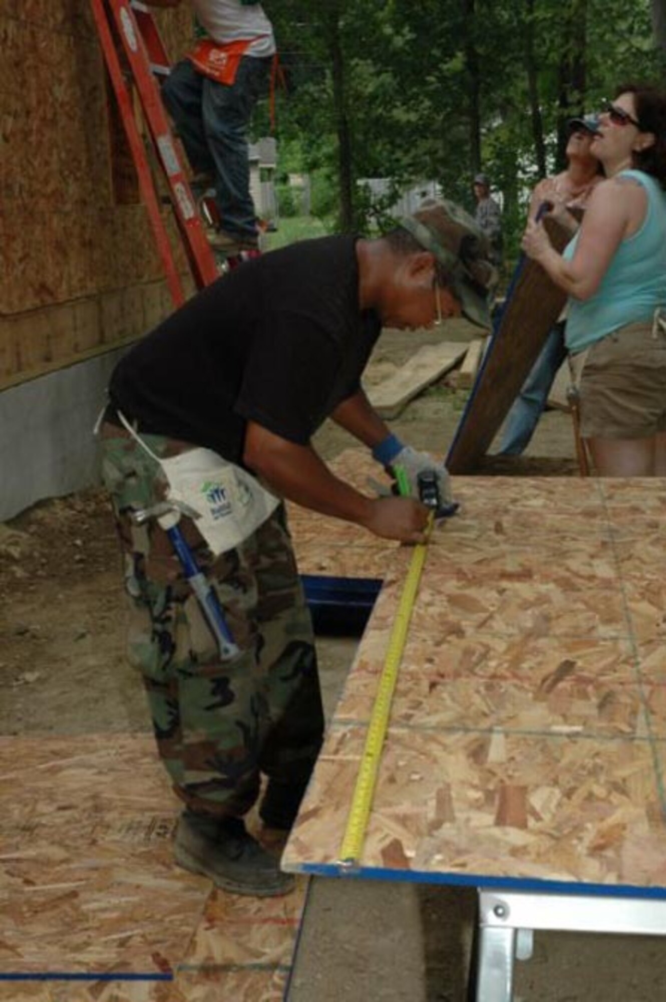 Tech. Sgt. Darin Ransaw of the 512th Civil Engineer Squadron, measures a piece of plywood to be cut during a Habitat for Humanity build in Dover, Del., June 5. The plywood was used for the roof of the house. More than seven Airmen are helping the organization build the house, which is scheduled to be completed in about six months. (U.S. Air Force photo/Staff Sgt. James Bolinger)