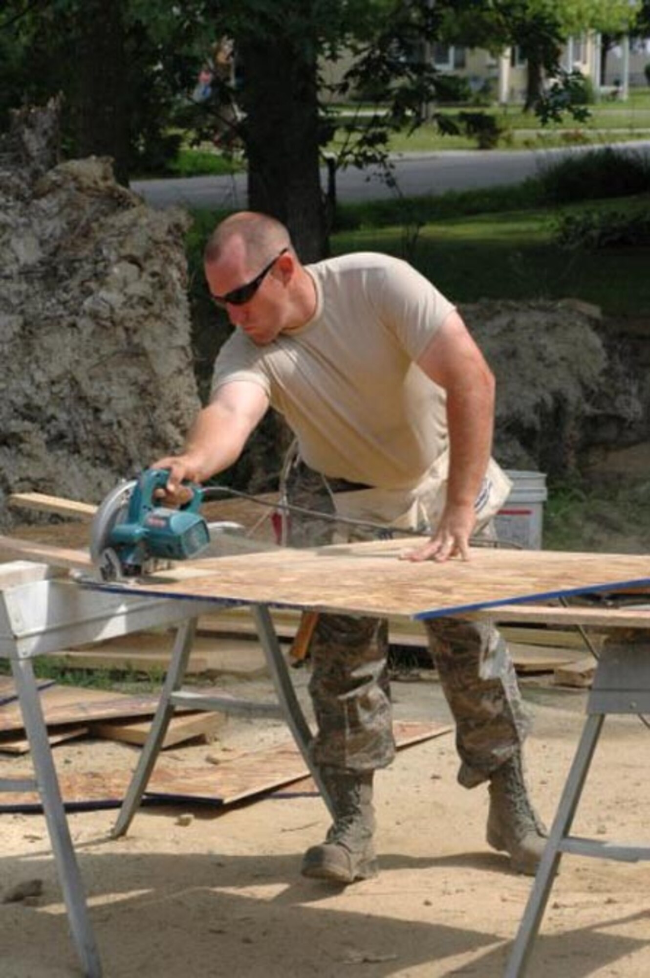 A 512th Airlift Wing member cuts a piece of plywood using a circular saw June 5 at a Habitat for Humanity build site in Dover, Del. The plywood was used to build the roof of the house. More than seven Reserve Airmen helped during the day's construction. (U.S. Air Force photo/Staff Sgt. James Bolinger)