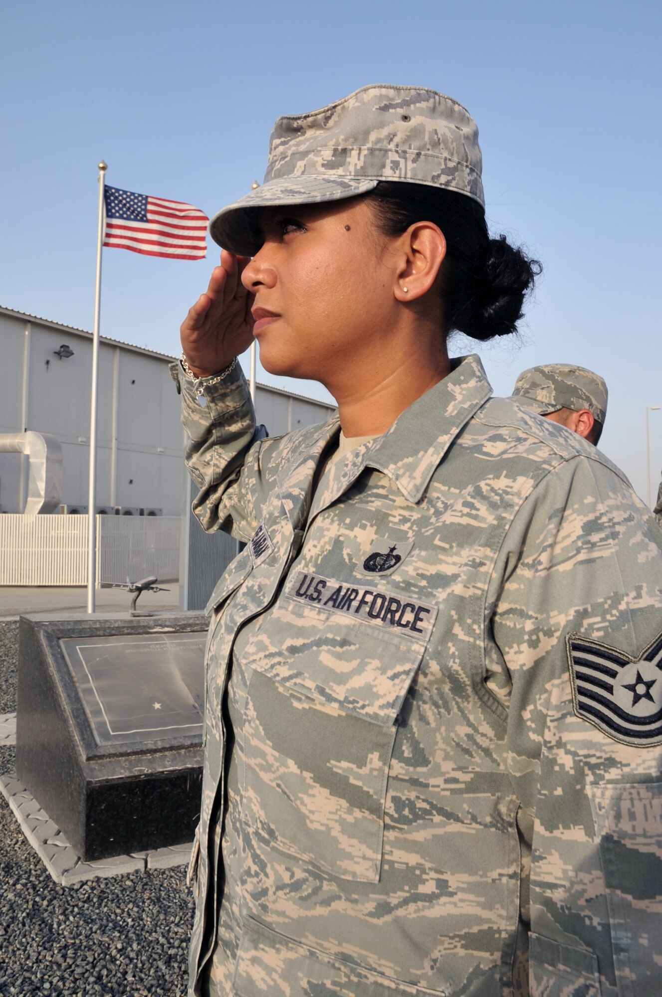 Tech. Sgt. Cynthia Fejaran, services craftsman, and other Airmen from the 380th Expeditionary Force Support Squadron salute during the playing of the national anthem during a ceremony at a non-disclosed base in Southwest Asia on May 29, 2010. Sergeant Fejaran is deployed from the Guam Air National Guard's 254th FSS at Anderson Air Base and his hometown is Asan, Guam. (U.S. Air Force Photo/Master Sgt. Scott T. Sturkol/Released)