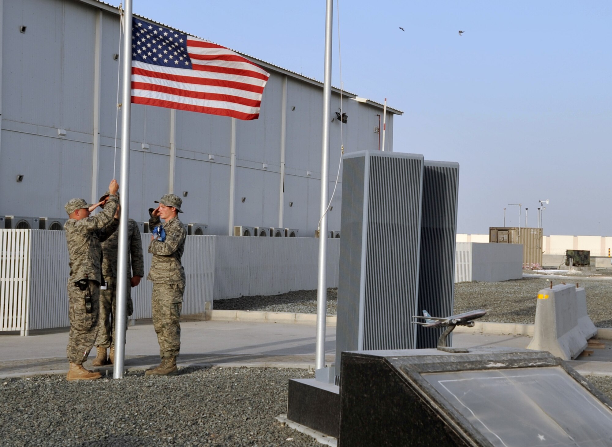 Firefighters from the 380th Expeditionary Civil Engineer Squadron Fire Department prepare to lower the American flag at the 380th Air Expeditionary Wing's 9-11 memorial at the end of the duty day at a non-disclosed base in Southwest Asia on May 29, 2010.  The memorial is a tribute to the men and women who died in the terrorist attacks in the United States on Sept. 11, 2001. The wing is home to the KC-10 Extender, U-2 Dragon Lady, E-3 Sentry and RQ-4 Global Hawk aircraft. The 380th AEW is comprised of four groups and 12 squadrons and the wing's deployed mission includes air refueling, air battle management, intelligence, surveillance and reconnaissance in support of overseas contingency operations in Southwest Asia. The 380th AEW supports operations Iraqi Freedom and Enduring Freedom and the Combined Joint Task Force-Horn of Africa. (U.S. Air Force Photo/Master Sgt. Scott T. Sturkol/Released)