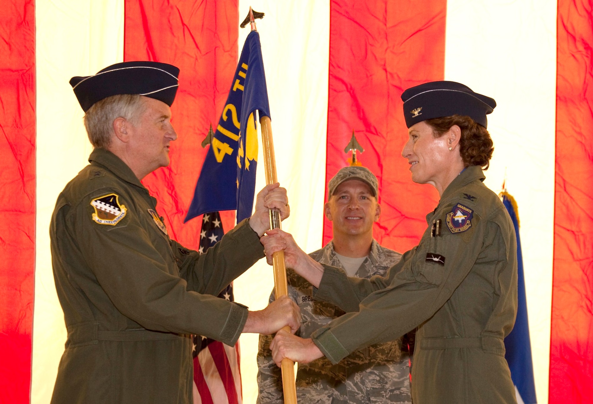 Maj. Gen. David Eichhorn, Air Force Flight Test Center commander, passes the 412th Test Wing flag to new commander Col. Dawn Dunlop during a change of command ceremony in Hangar 1600 June 4.  The passing of the flag officially transfers authority of the Wing to Colonel Dunlop. (Air Force photo by Greg L. Davis)