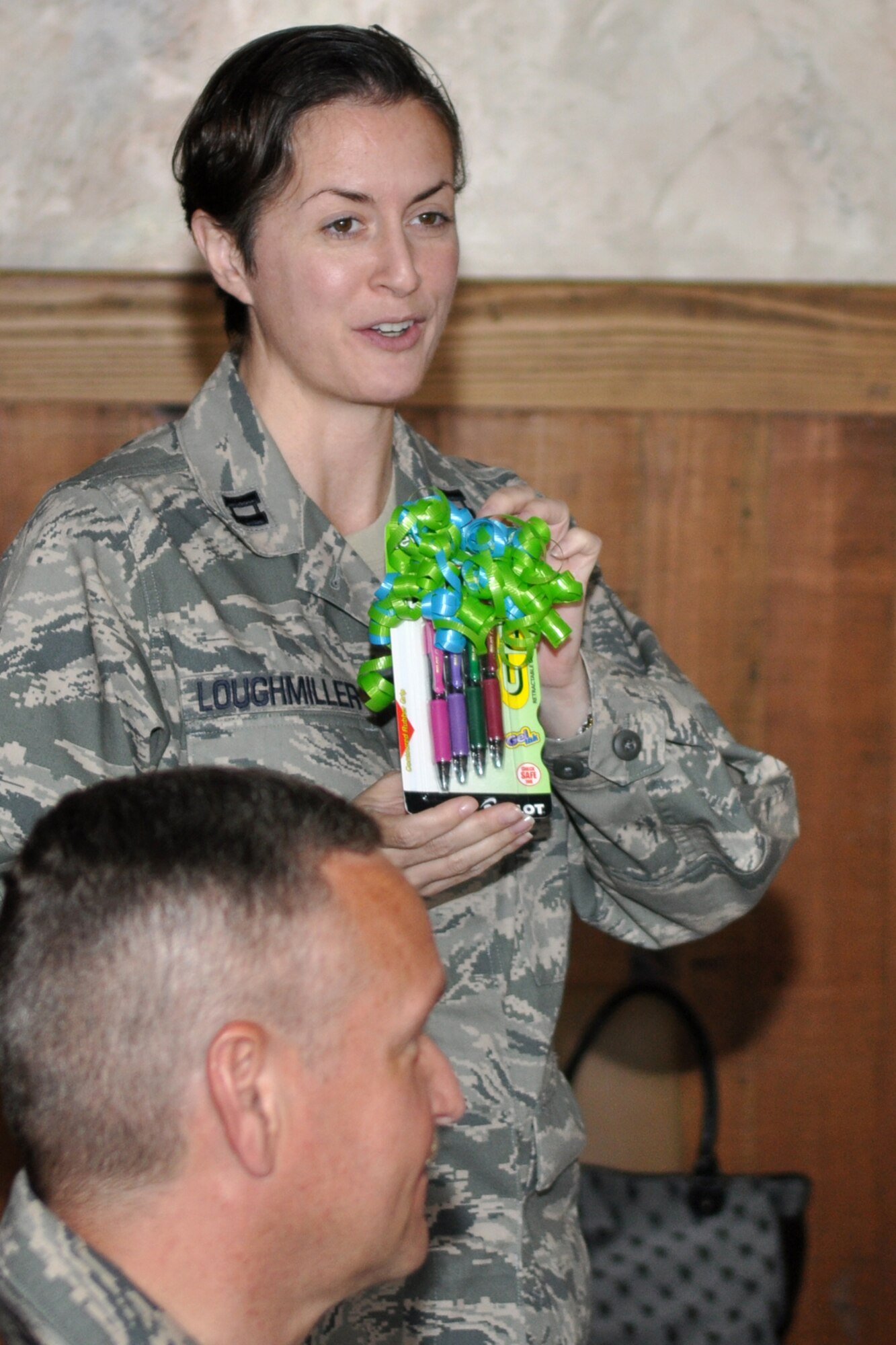Capt. Marlette Loughmiller showcases a set of colored pens she is presenting as a gag gift during the farewell luncheon for Capt. Stephanie Kennedy, executive officer of the 917th Wing.  Approximately 40 co-workers and friends gathered at a local eatery in Bossier City, La., May 27, 2010, to say goodbye to Capt. Kennedy, who is leaving Barksdale after three years of dedicated service. She will move forward with her career at Whiteman Air Force Base, Mo.  Capt. Kennedy has spent the last few weeks training and preparing Capt. Marlette Loughmiller, who will act as the interim executive officer until a replacement can be hired. Originally from the East Texas area, Capt. Loughmiller comes to the 917th Wing from the 106th Rescue Wing, New York Air National Guard. (U.S. Air Force photo/Tech. Sgt. Jeff Walston)    