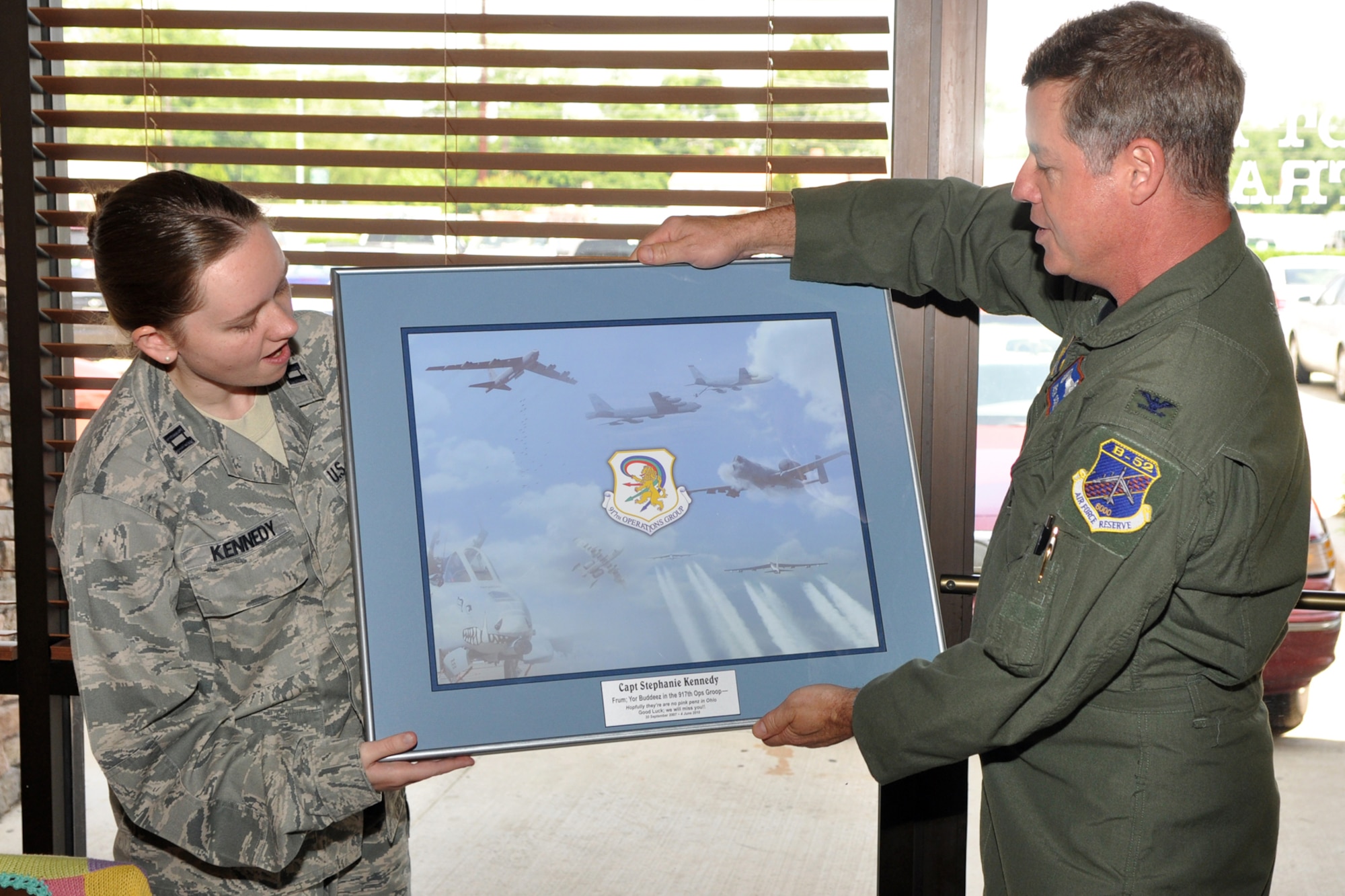Col. Keith Schultz, commander, 917th Operations Group presents a parting gift to Capt. Stephanie Kennedy, executive officer, 917th Wing during her farewell luncheon at a local eatery in Bossier City, La., May 27, 2010. Approximately 40 co-workers and friends gathered to say goodbye to Capt. Kennedy, who is leaving Barksdale after three years of dedicated service. She will move forward with her career at Whiteman Air Force Base, Mo. (U.S. Air Force photo/Tech. Sgt. Jeff Walston)    