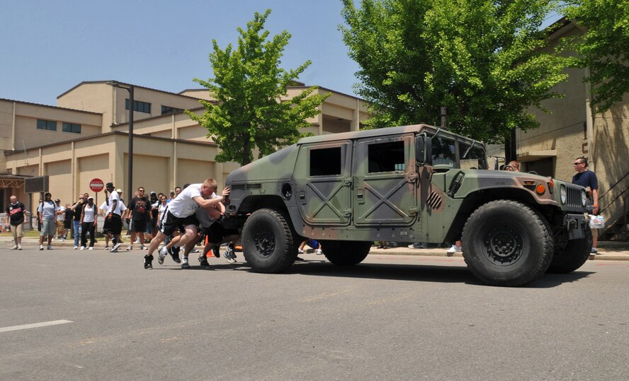 Staff Sgt. Angel Munoz, Tech. Sgt. Parrish Johnson, Airman 1st Class Zachary Moore, Airman 1st Class Elijah Toth and Airman 1st Class John Ozborne, 8th Communications Squadron, push their way to a win during a Humvee push competition May 21 at Kunsan Air Base, Republic of Korea. The event was one of many junior Wolf Pack Airmen participated in for the 8th Fighter Wing Junior Enlisted Appreciation Day. The challenge was for the teams to pus the Humvee to a specified distance within the quickest time. The Top III Association sponsored the day of music, sports, food and fun as a way to thank junior enlisted members for the hard work they do every day to accomplish the wing's mission. (U.S. Air Force photo/Capt. Shannon Collins)