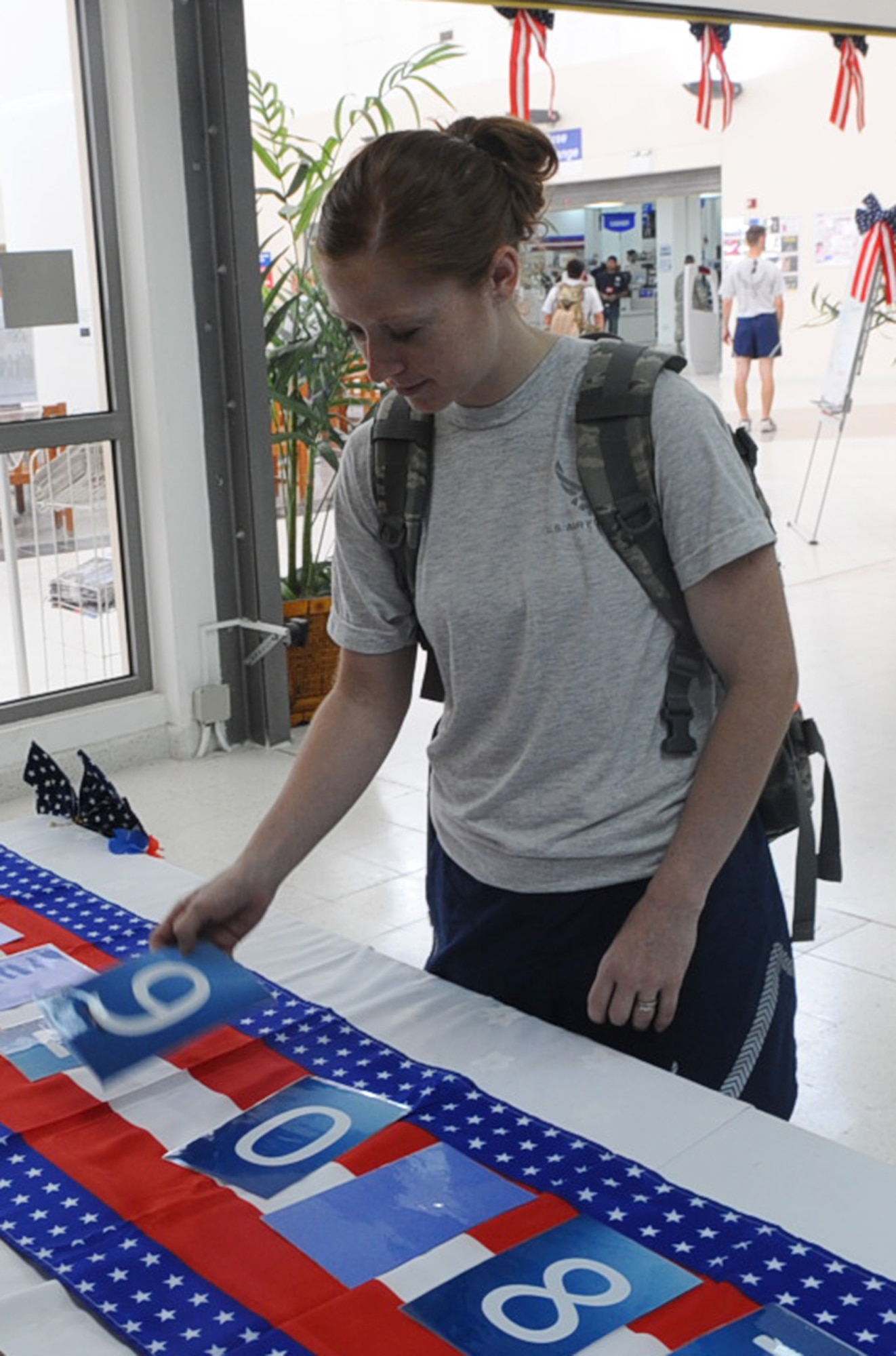 Staff Sgt. Bonita Hummel, 609th Combined Air Operations Center imagery analyst, turns over a card while playing High/Low during the Memorial Day Holiday Carnival at a non-disclosed Southwest Asia location May 31, 2010. (U.S. Air Force photo by Senior Airman Kasey Zickmund)[RELEASED]