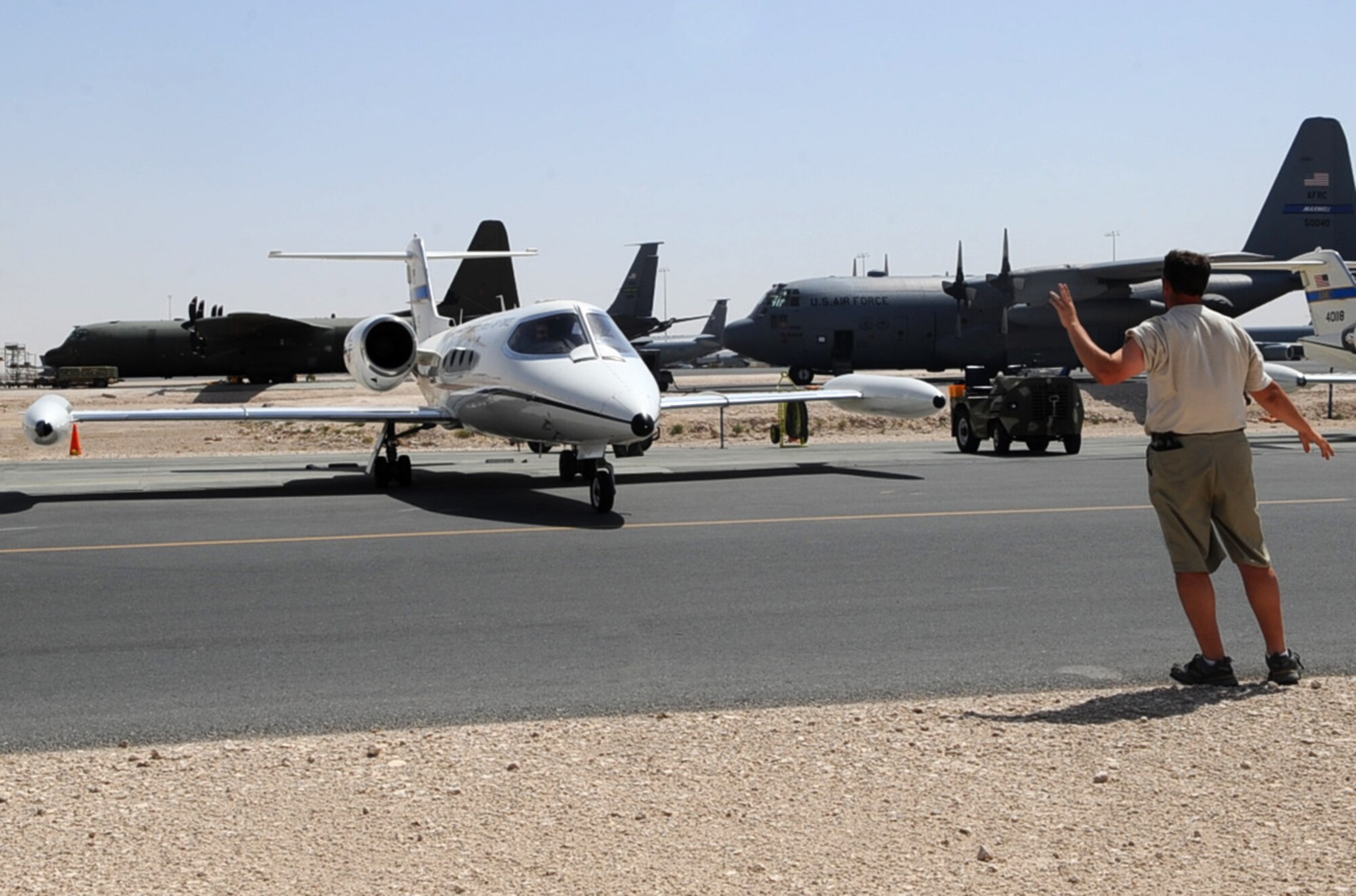 Mark Hilton, air frame and power plant technician contractor, marshals out a C-21 for a flying mission at a non-disclosed Southwest Asia location May 28, 2010. (U.S. Air Force photo by Senior Airman Kasey Zickmund) [RELEASED]