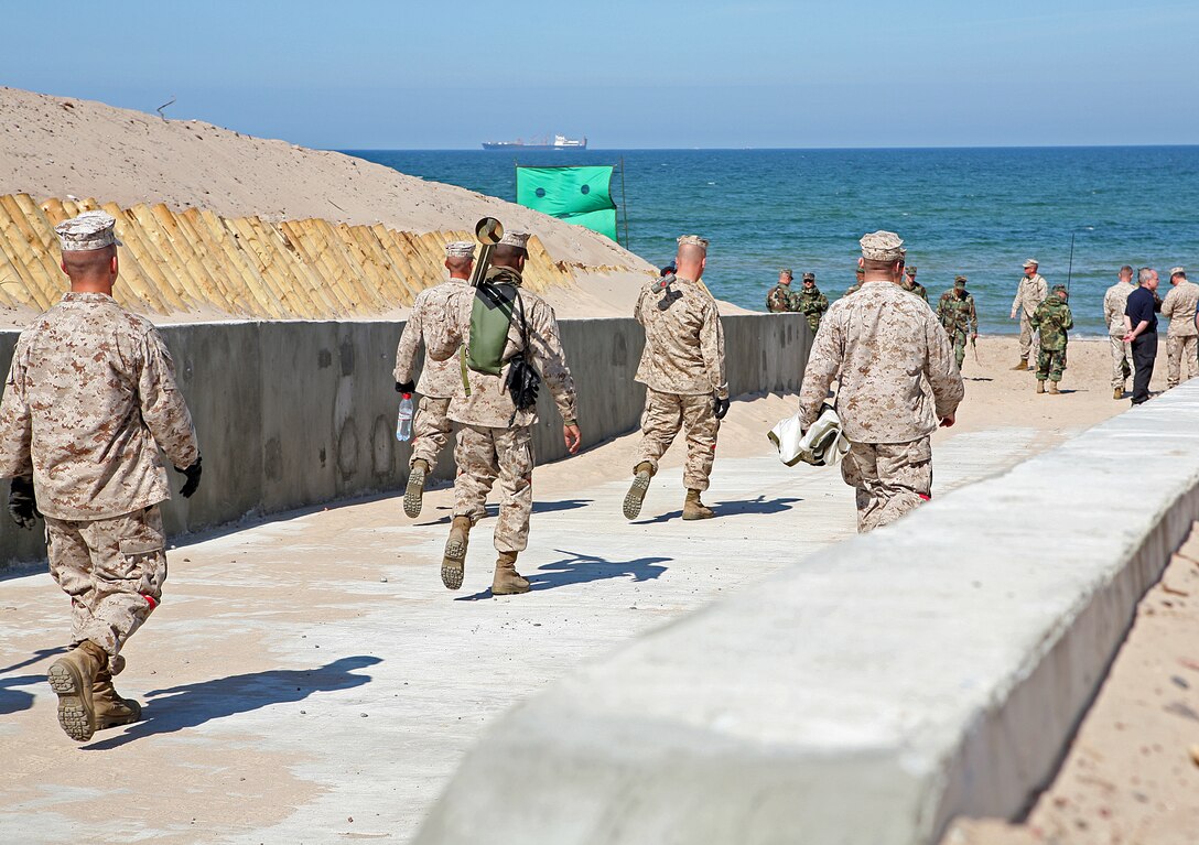 Landing support Marines from Charlie Company, 4th Landing Support Battalion, 4th Marine Logistics Group, head to the beach to set up signal flags to mark the landing area here. The maritime preposition force (MPF) offload conducted here today begins the first phase of the MPF portion of exercise BALTIC OPERATIONS 2010, a multinational maritime exercise designed to increase interoperability between the 12 participating nations and increase maritime safety and security.