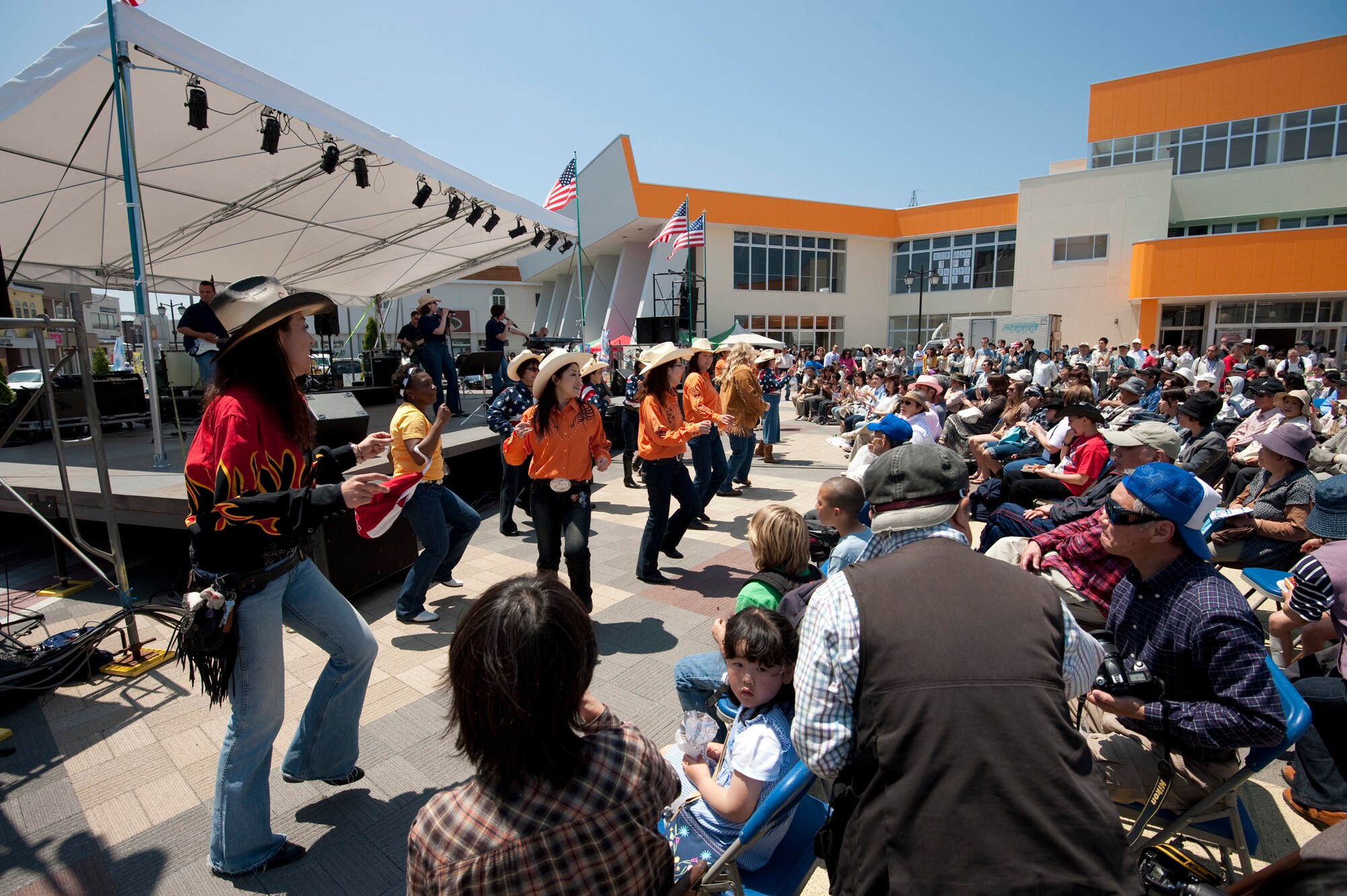 MISAWA CITY, Japan -- Spectators get up and dance to music performed by Pacific Trends, U.S. Air Force Band of the Pacific - Asia, at American Park during American Day, June 6. The Towada Horseback Riding Club country line danced, encouraging others to join-in. (U.S. Air Force photo/Staff Sgt. Samuel Morse)
